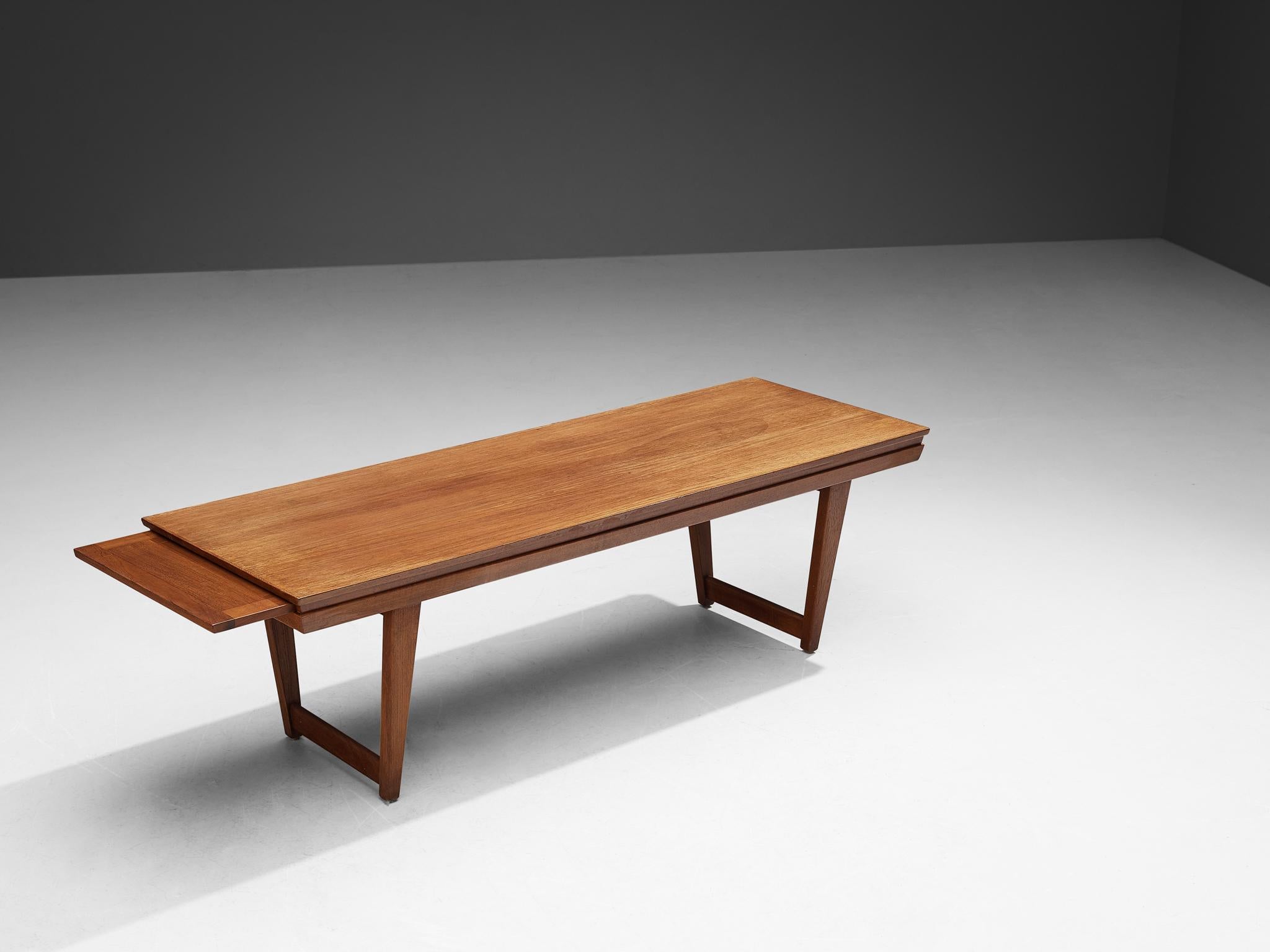 Coffee table, teak, Denmark, 1960s.

Large Danish extendable coffee table executed in solid teak. The model shows a long, rectangular top with vivid wood grain. On both ends, this table contains an extra table leaf to the extend the width even