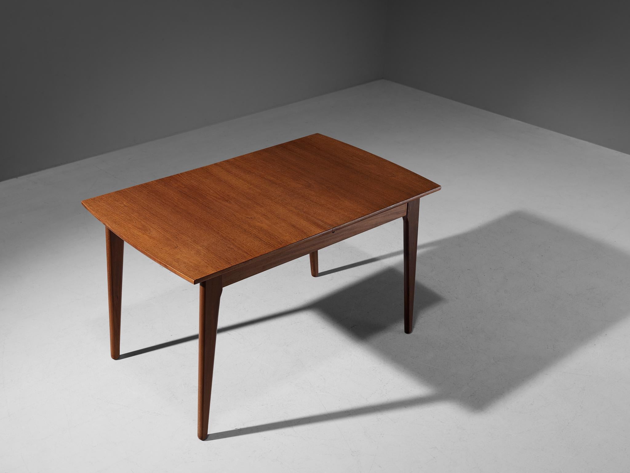 Dining or kitchen table, teak, Denmark, 1950s.

Characteristic Danish extendable dining table executed in teak. This table contains two extra leaf that can be placed in the middle part of the table top. A warm appearance is realized by the vibrant