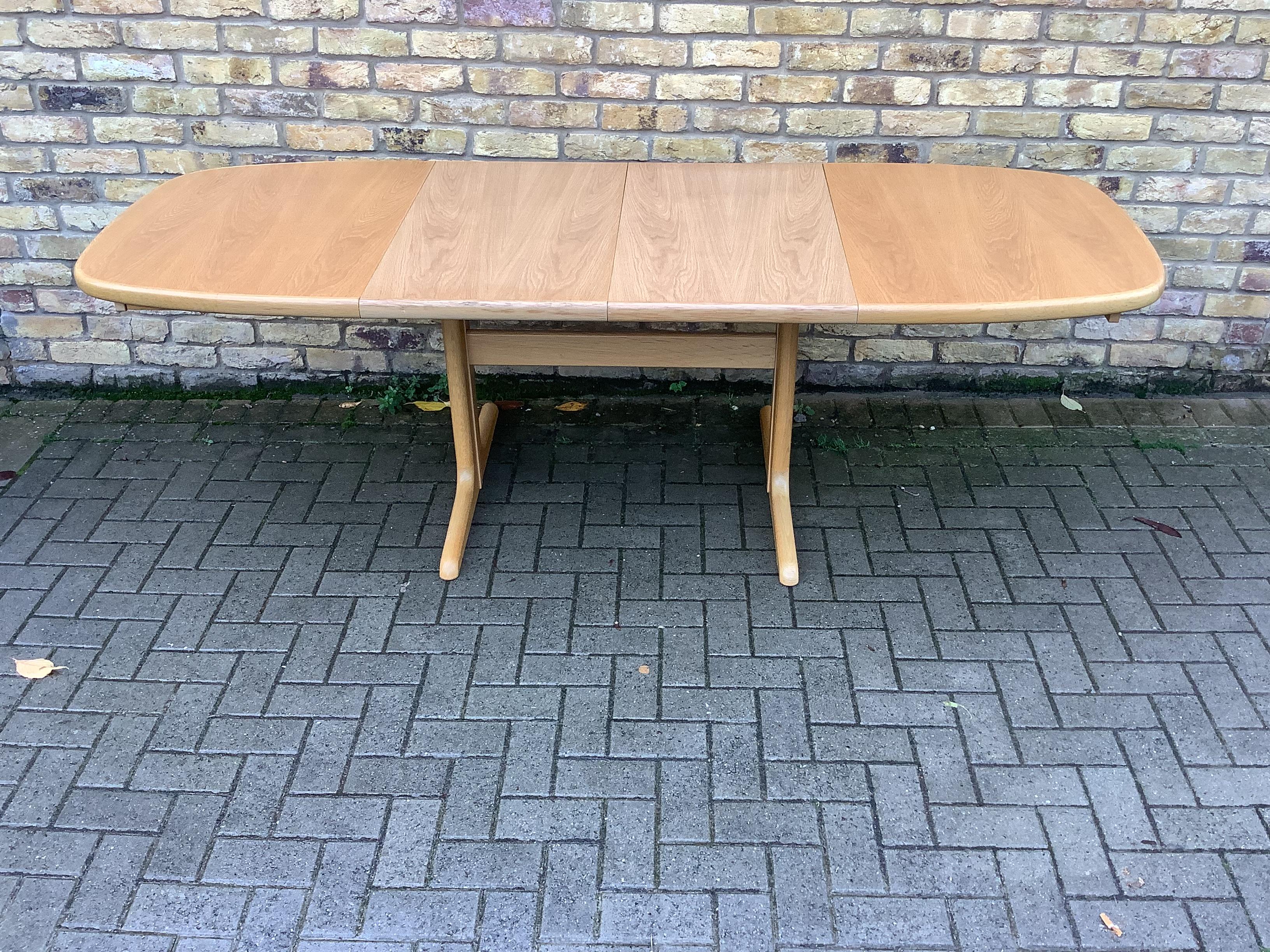 Il s'agit d'un chêne  Table de salle à manger à rallonge fabriquée au Danemark par Skovby et datant probablement de la fin du vingtième siècle. La table est principalement de forme rectangulaire avec des extrémités arrondies et s'étend avec