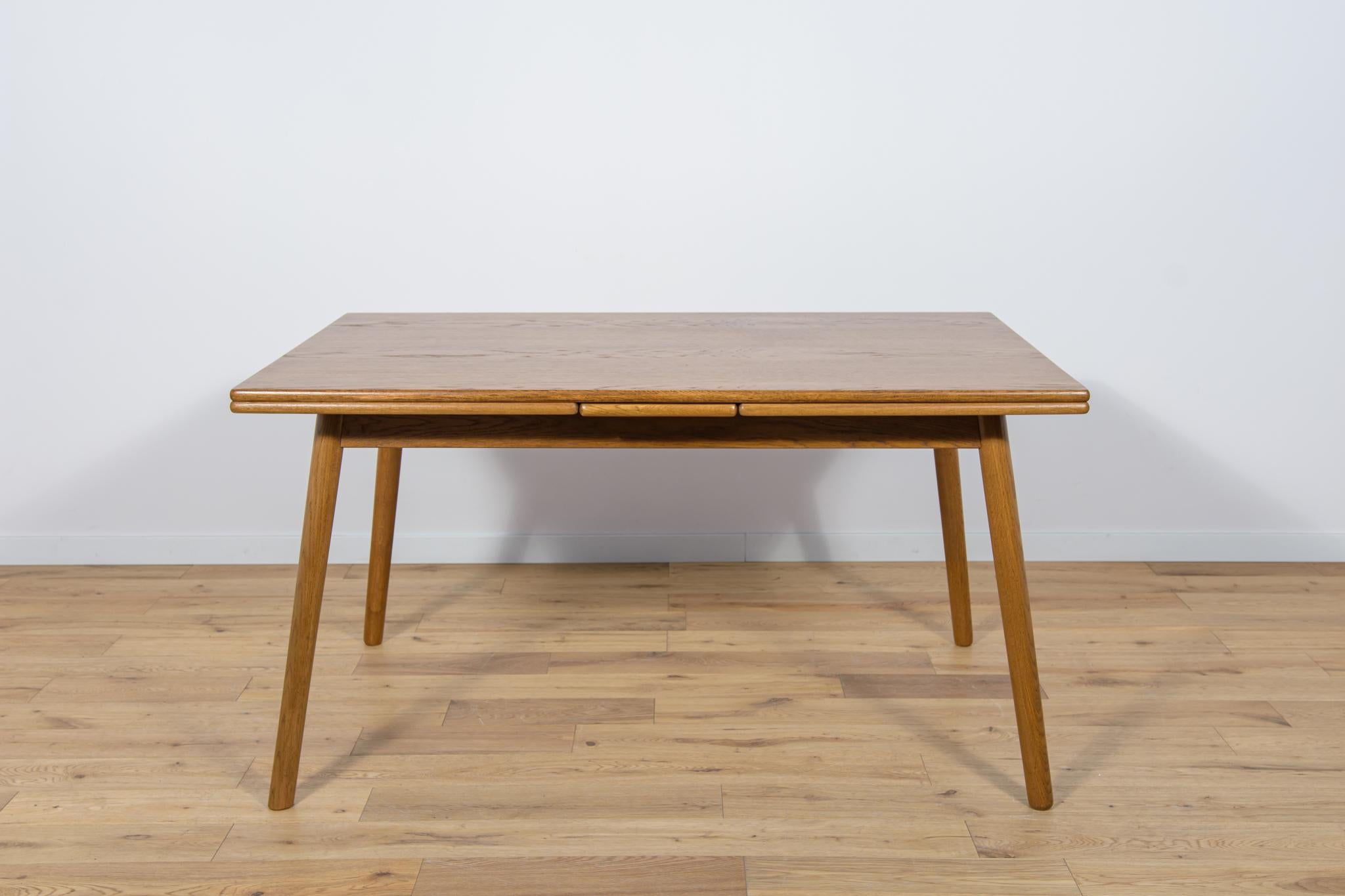 The extendable oak wood table was produced in Denmark in the 1960s. The unique character of the table was given by placing legs at an angle. The furniture has been completely renovated, cleaned of the old coating, stained with oak stain, finished