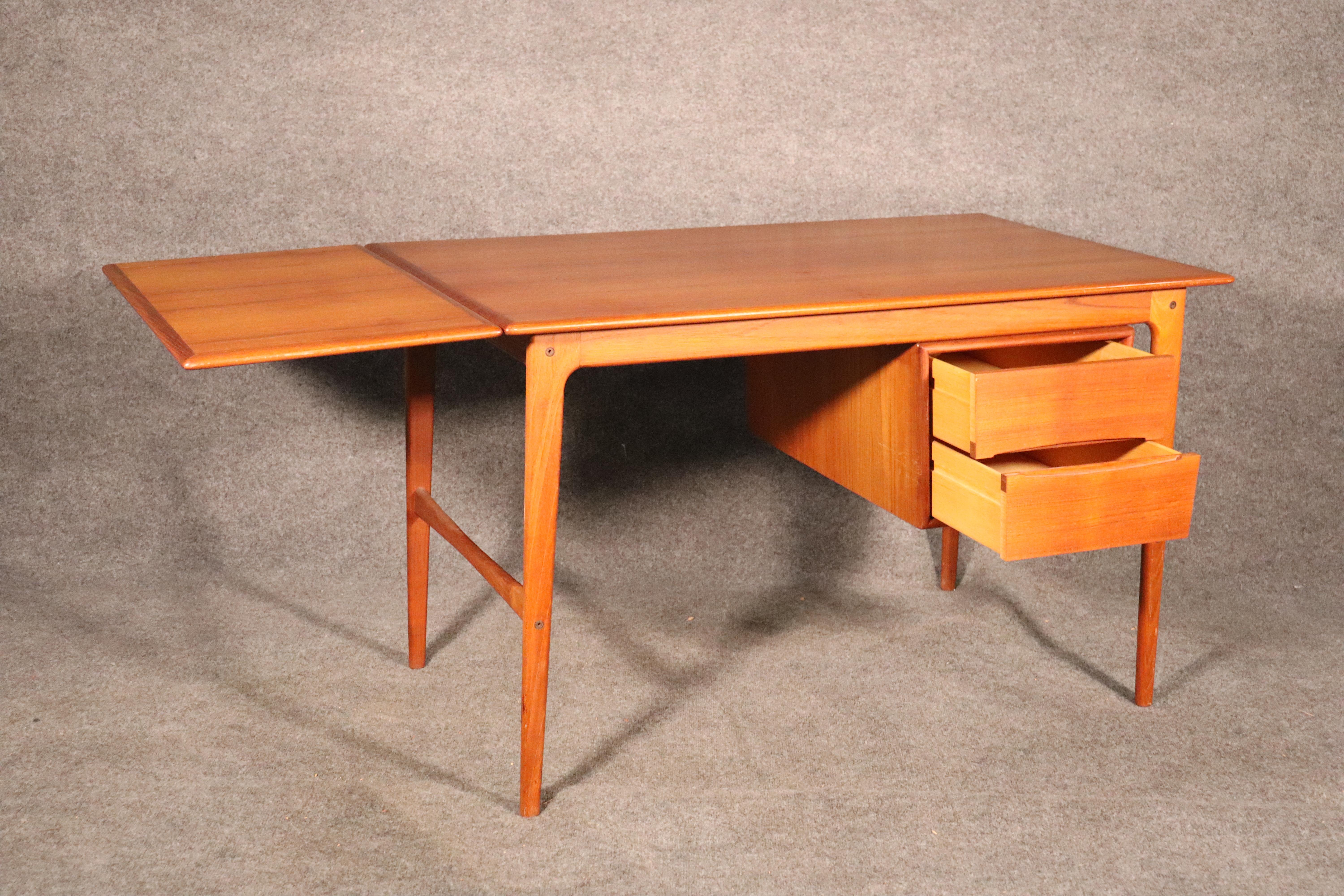 Mid-Century Modern desk from Denmark in teak wood. Space saving feature with a sliding top to extend the desk 46