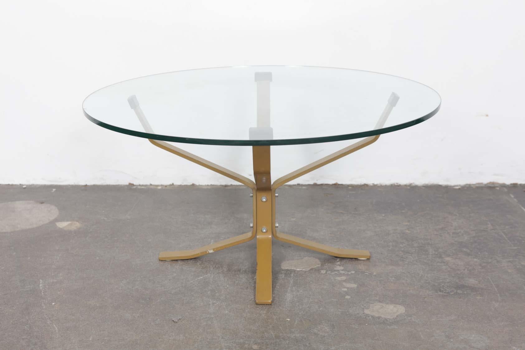 Unique Danish made solid flat bar metal coffee table with glass top, finished in a brass tone, designed in the manner of a falcon chair or ntable by Sigurd Ressel. Condition of base is good, with wear consistent of its age. Glass top shows some