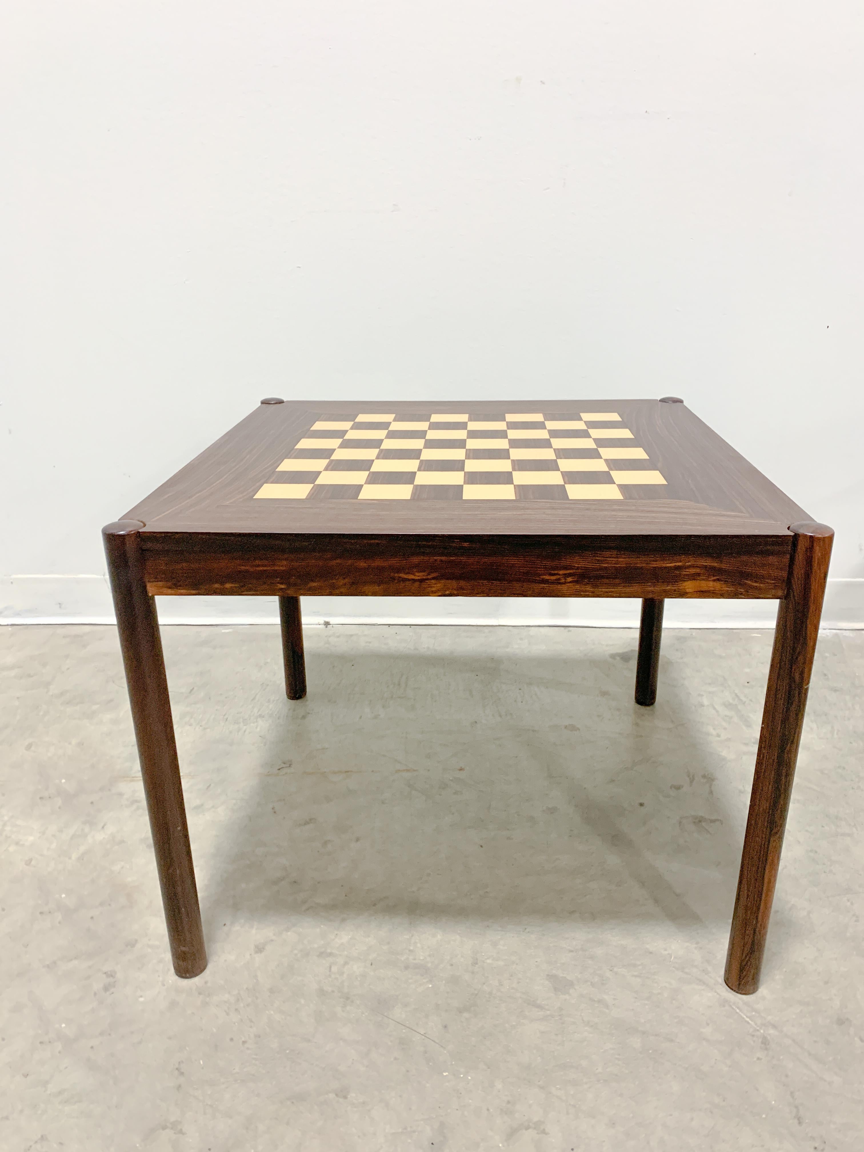 Eye-catching flip top chess table designed by George Petersen and made in Denmark. Solid rosewood legs with veneered top and sides. Chessboard on one side of top and rosewood grain on other. Legs bolt on making it easily collapsible for shipping or