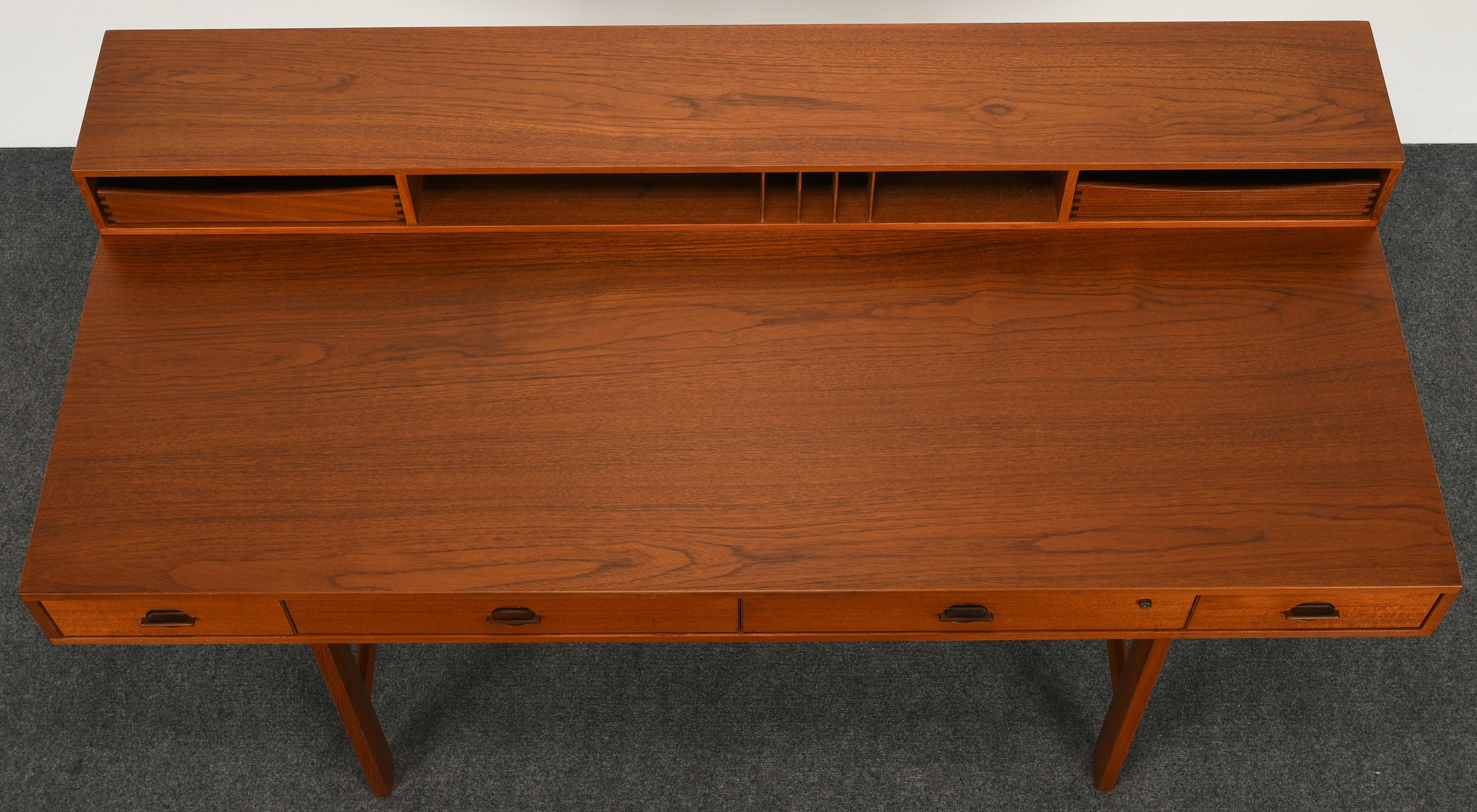 A beautiful expandable Danish modern teak partners desk with a flip-top design by Jens Quistgaard for Peter Lovig Nielsen. This desk can be used either flipped down for expansive space or flipped up for ample storage. Solid teak construction with a