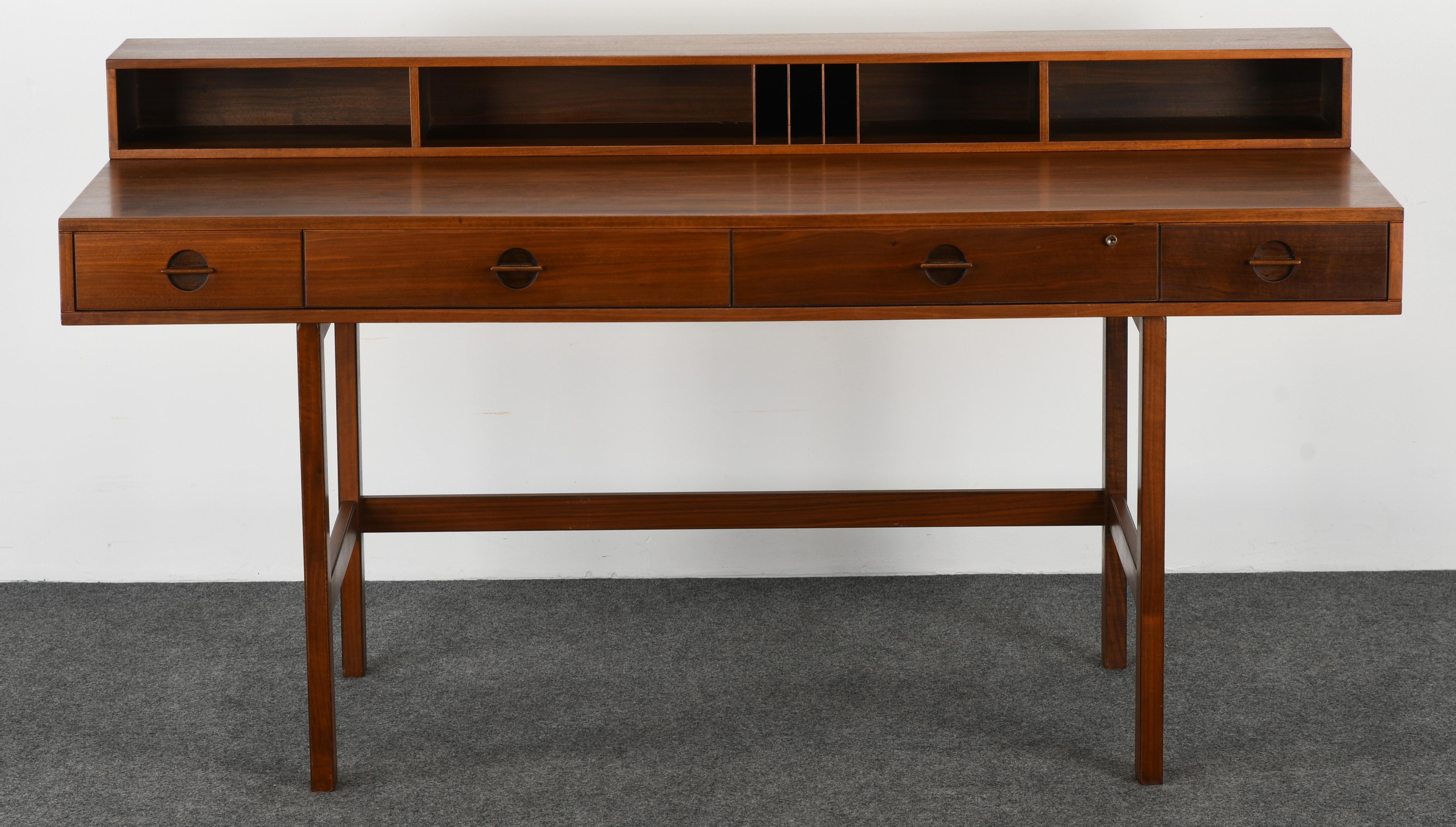 A beautiful expandable Danish Modern walnut partners desk with a flip-top design by Jens Quistgaard for Peter Lovig Nielsen. This desk can be used either flipped down for expansive space or flipped up for ample storage. Solid walnut construction