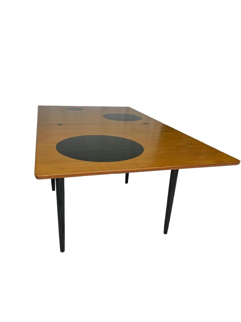 Indulge in mid-century charm with the Danish Teak Flip Top Game Table inspired by Grete Jalk. Crafted with exquisite teak wood, its sleek design boasts whimsical circle accents, adding a touch of playfulness to your space. The flip-top feature