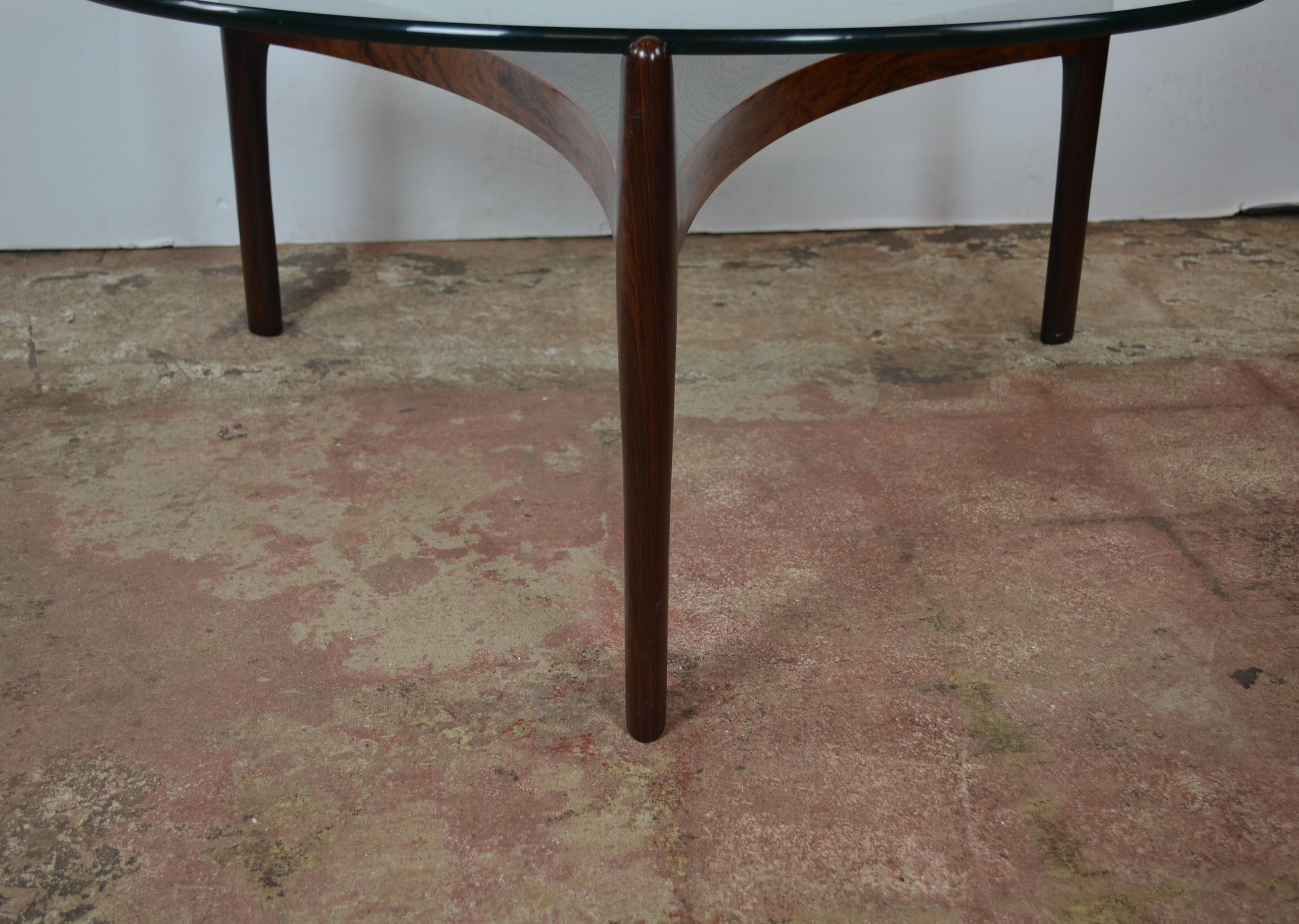 Rosewood reverse trefoil and round glass coffee table. A fine example of refined Danish design. Clean and sleek lines, bookmatched six part parquetry center. Three legs are notched at the top to secure the 1/2