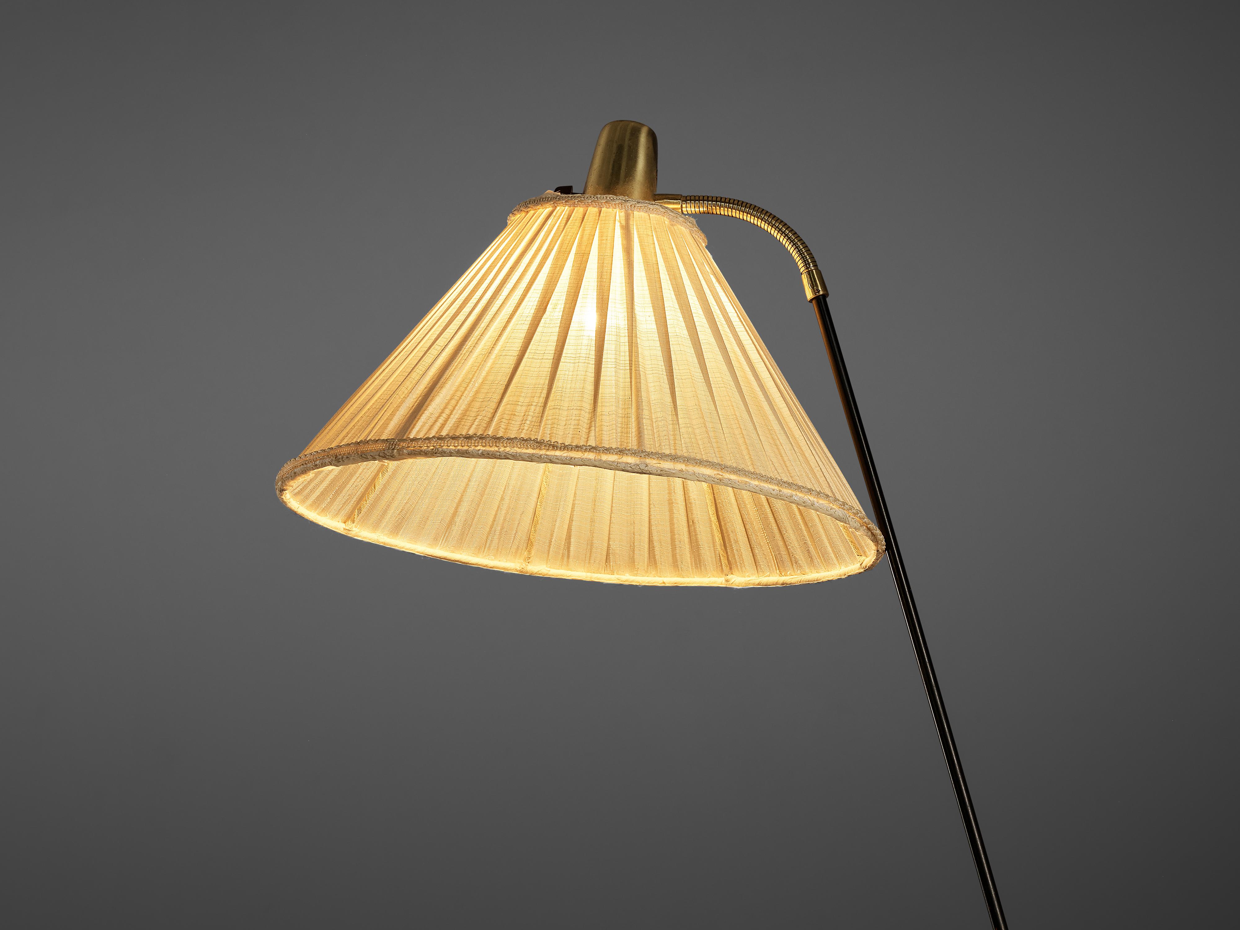 Floor lamp, metal, brass, fabric, Denmark, 1950s

This exquisite floor lamp was designed in Denmark in the 1950s. It has a very light character evoked due to the thin metal stem that rests on a tripod base ending in circular feet. Therefore the