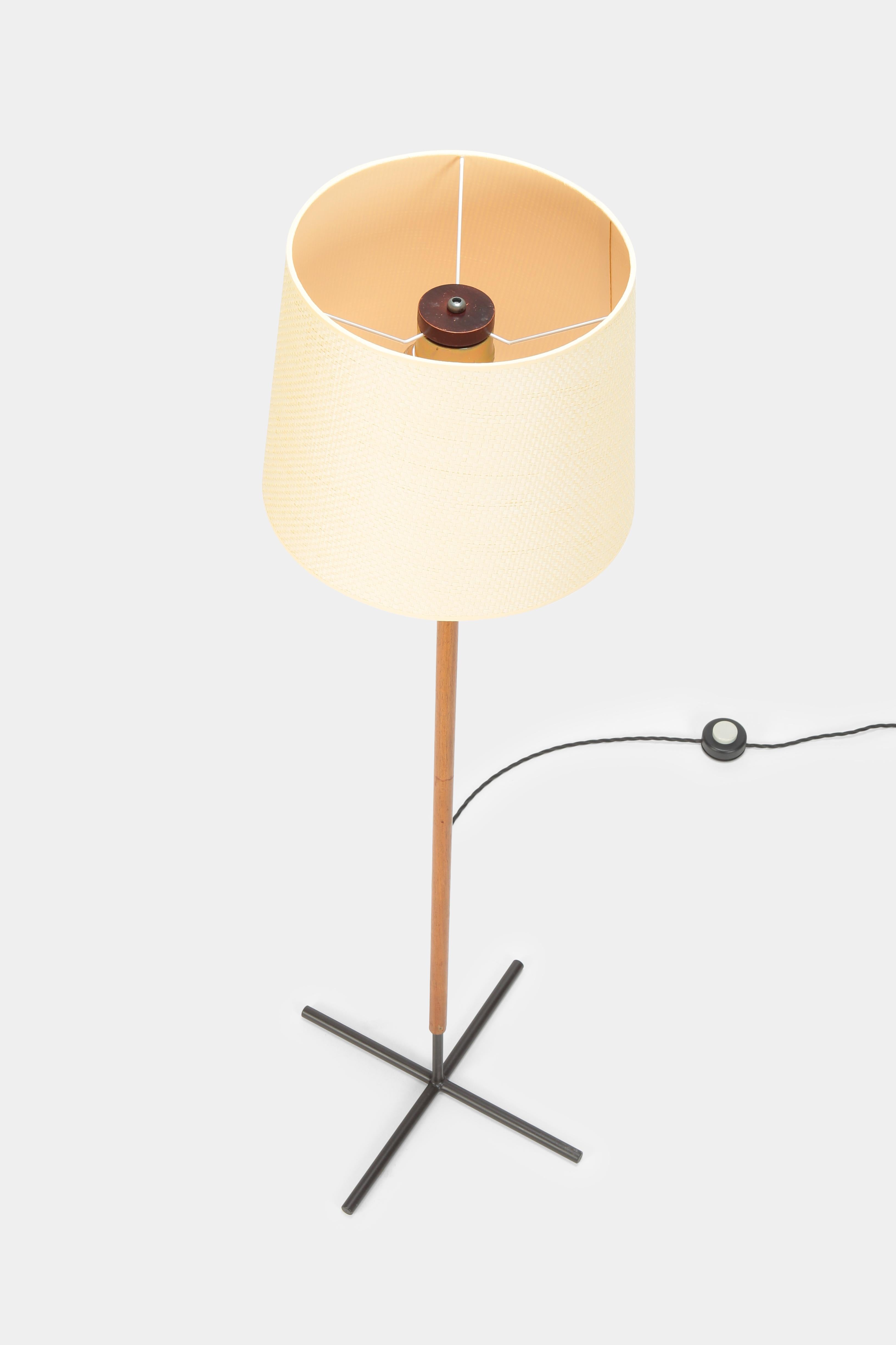 Elegant floor lamp manufactured in the 1950s in Denmark. Black lacquered base, solid teak wood column on top and a new woven lamp shade.