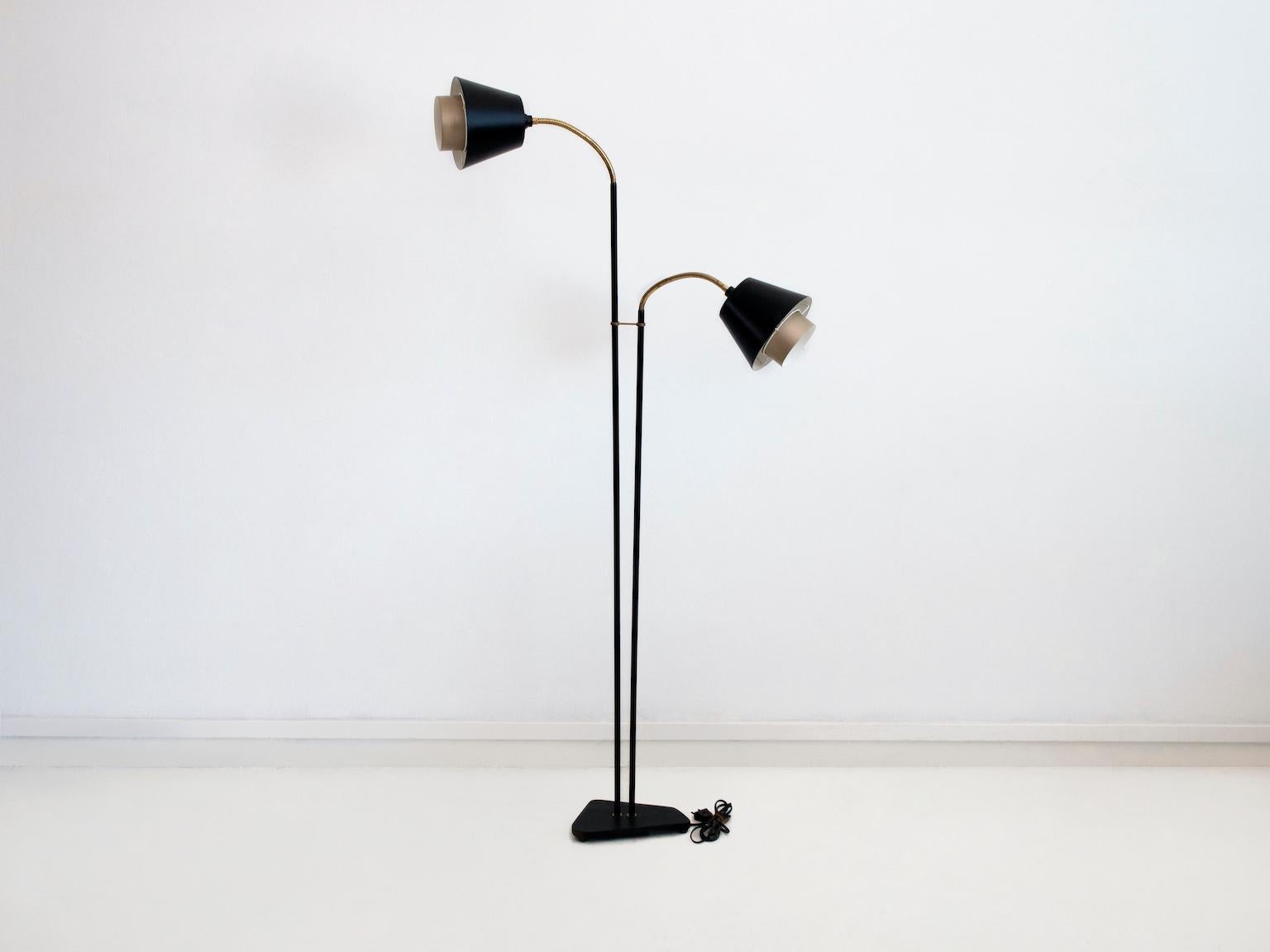 Floor lamp of black lacquered metal with two flexible arms of brass. Aluminum shades lacquered in copper and black. Manufactured in Denmark, circa 1960. European plug.