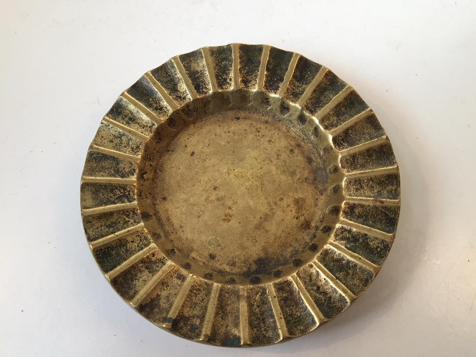 This decorative and heavy ashtray or coin tray comes in partially fluted cast bronze. It was manufactured by Ægte Bronce in Denmark during the 1930s. The style of this piece is reminiscent of the designs by Tinos and Vendor.