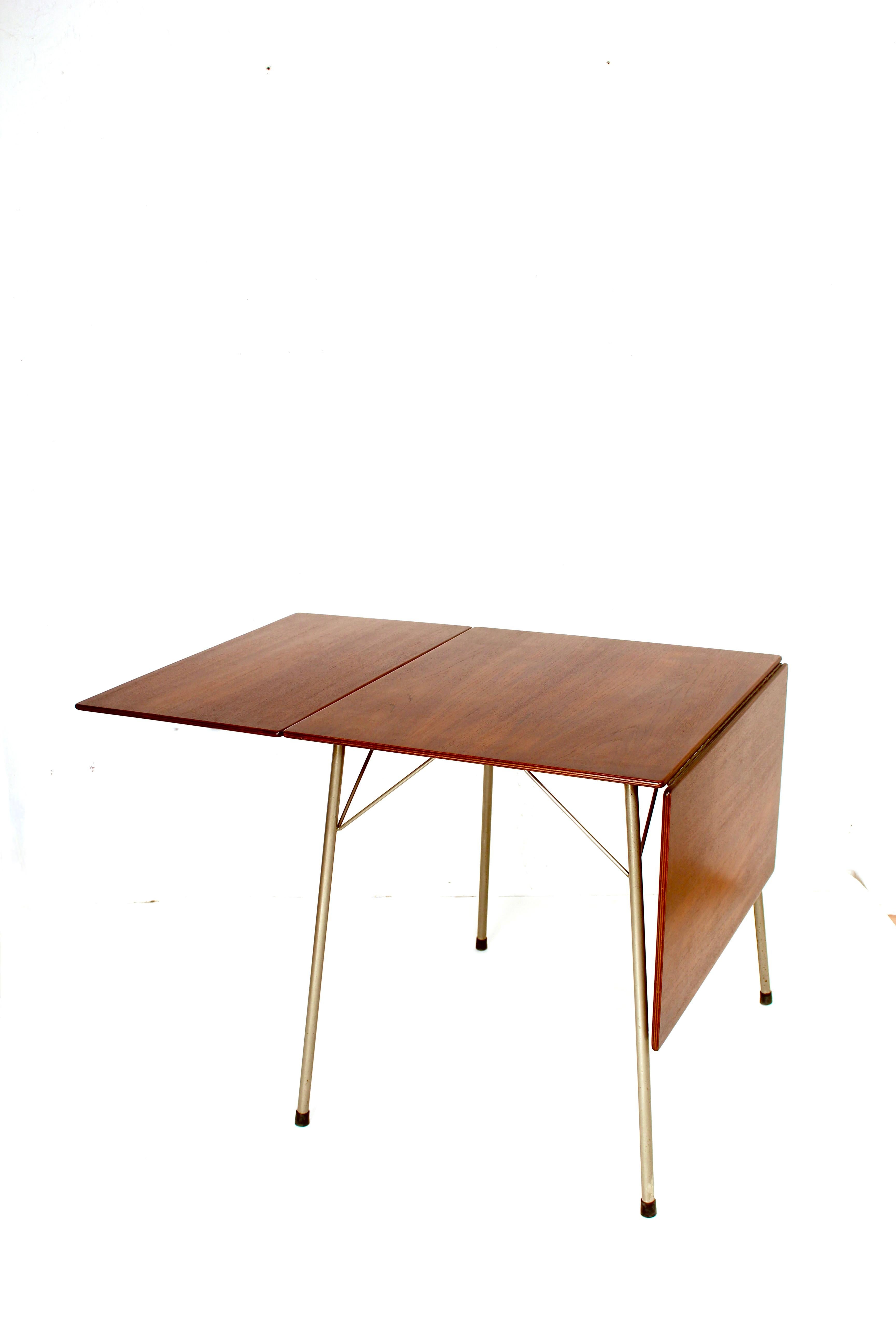 Nice small drop-leaf table model 3601 designed by Arne Jacobsen for Fritz Hansen, Denmark, 1952. This table has a teak wooden foldable top and chrome-plated tubular metal legs. This rare table is very nice sized and easy to fold. When fully extended