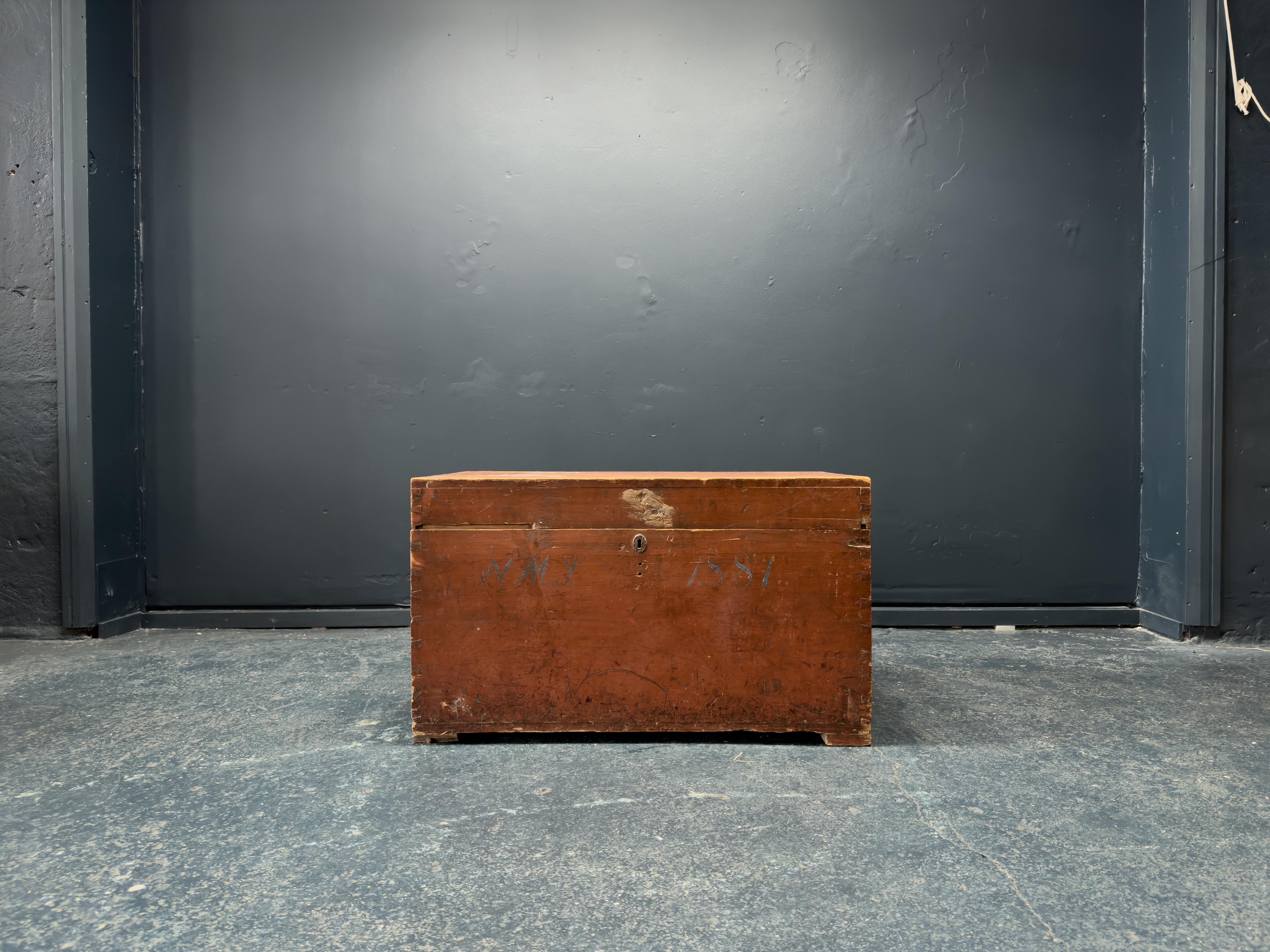 This incredible Danish folk linen chest is full of life and character. With a red patina to the wood and original metal hardware, this is a gorgeous historic piece. The year 1881 delicately painted upon the front of the chest can be seen alongside a