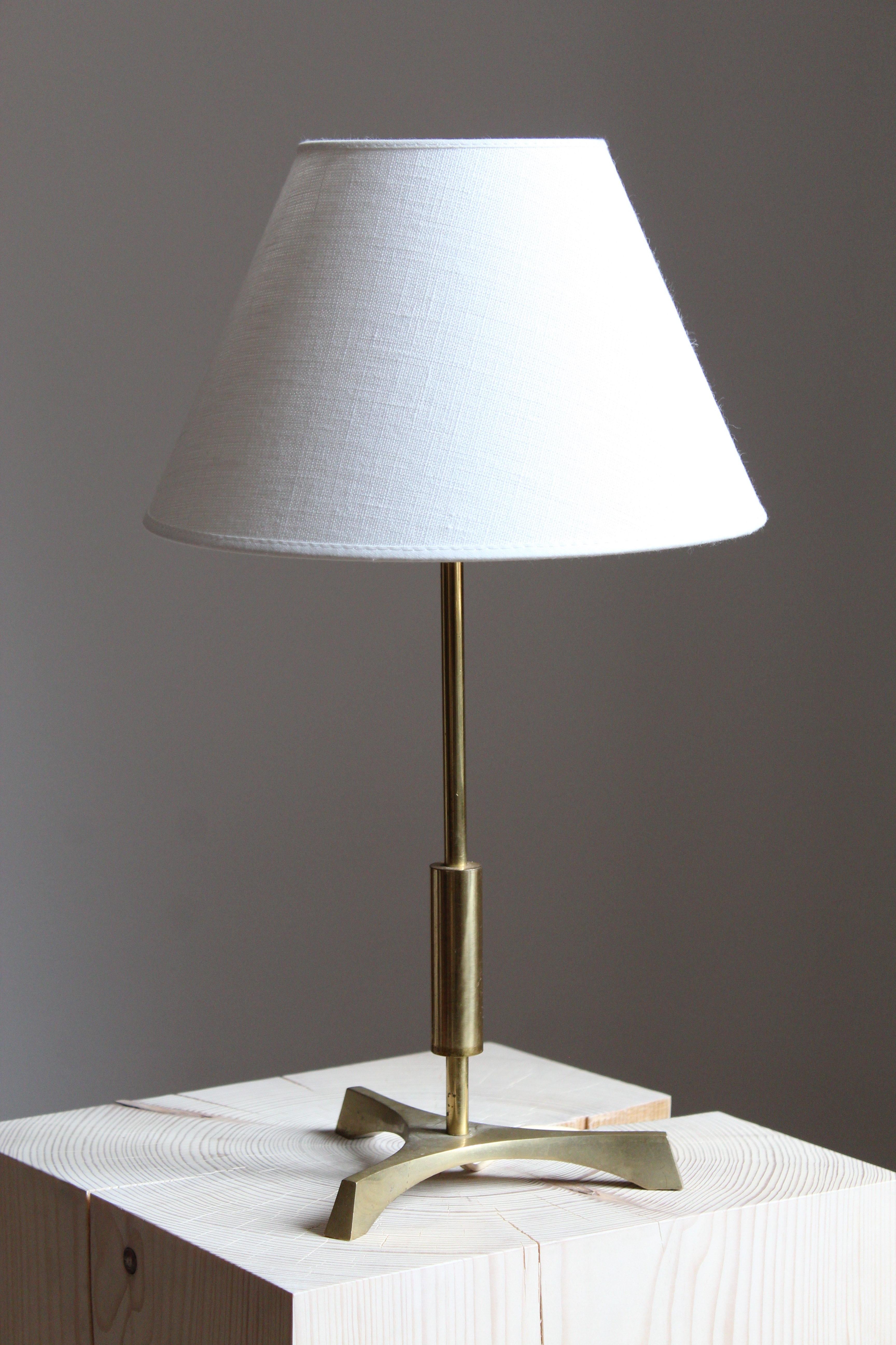 A table lamp. Designed and produced in Denmark in the 1950s. In brass. Brand new linen lampshade.

 