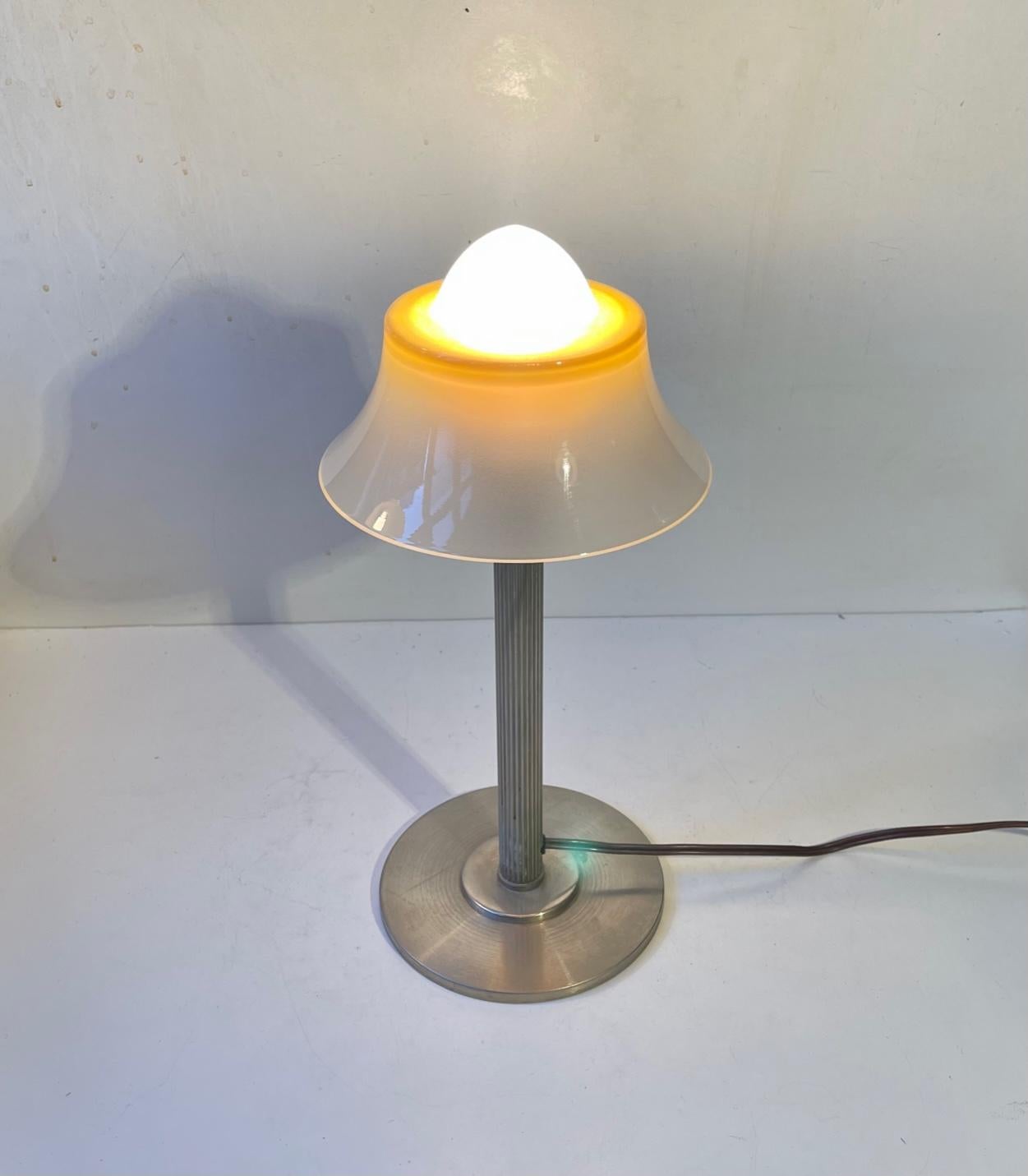 Danish Art Deco/Functionalist table light manufactured by Fog and Mørup during the 1930s. It features a fluted nickel-plated metal base and single layered, partially painted vaseline glass shade that resembles a fried egg - hence its name. This