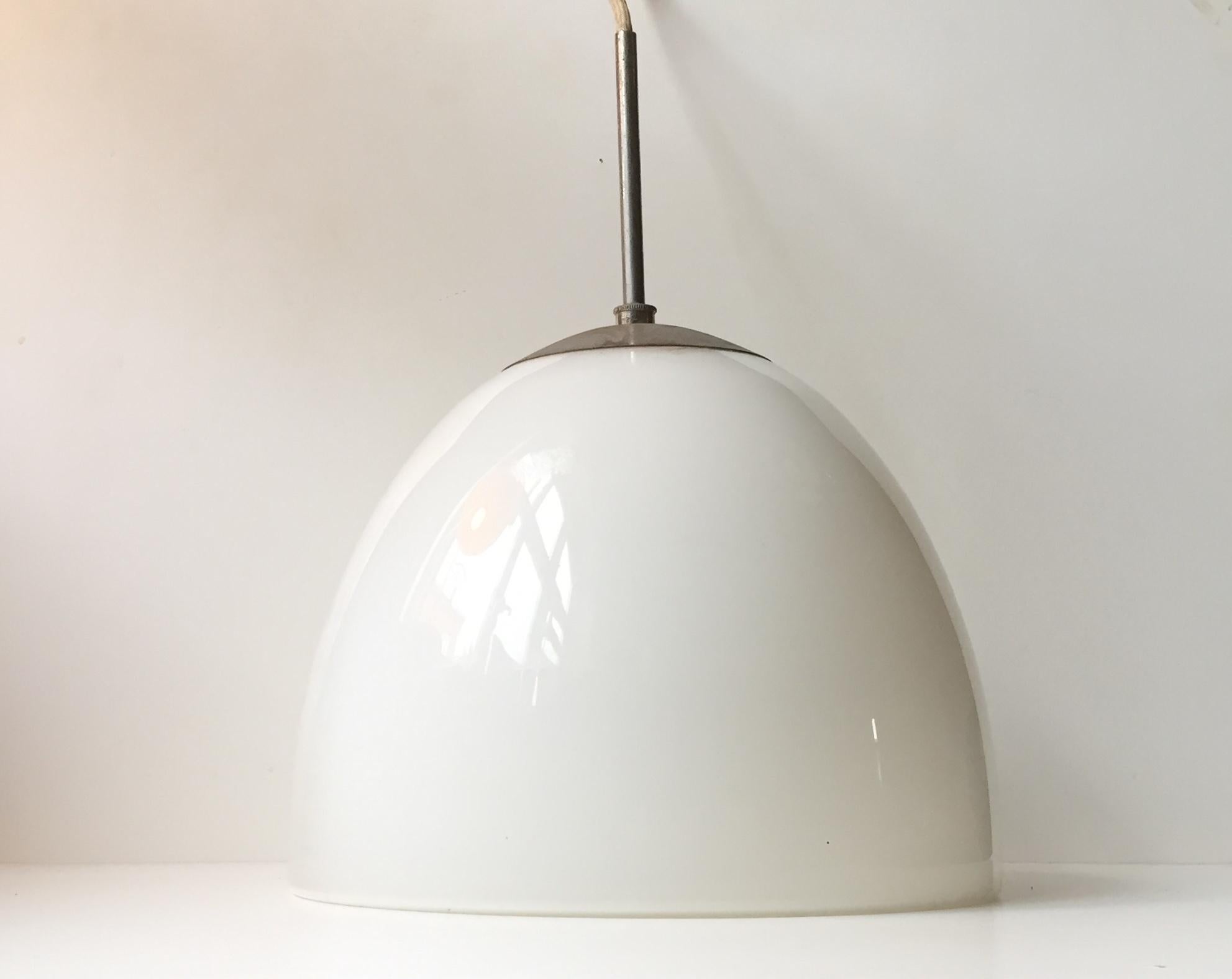 This white opal glass and chromed Steel Bell shaped pendant light was manufactured by Louis Poulsen in Denmark during the 1950s. The style is Funkis or Bauhaus and design is reminiscent of works from Vilhelm Lauritzen.