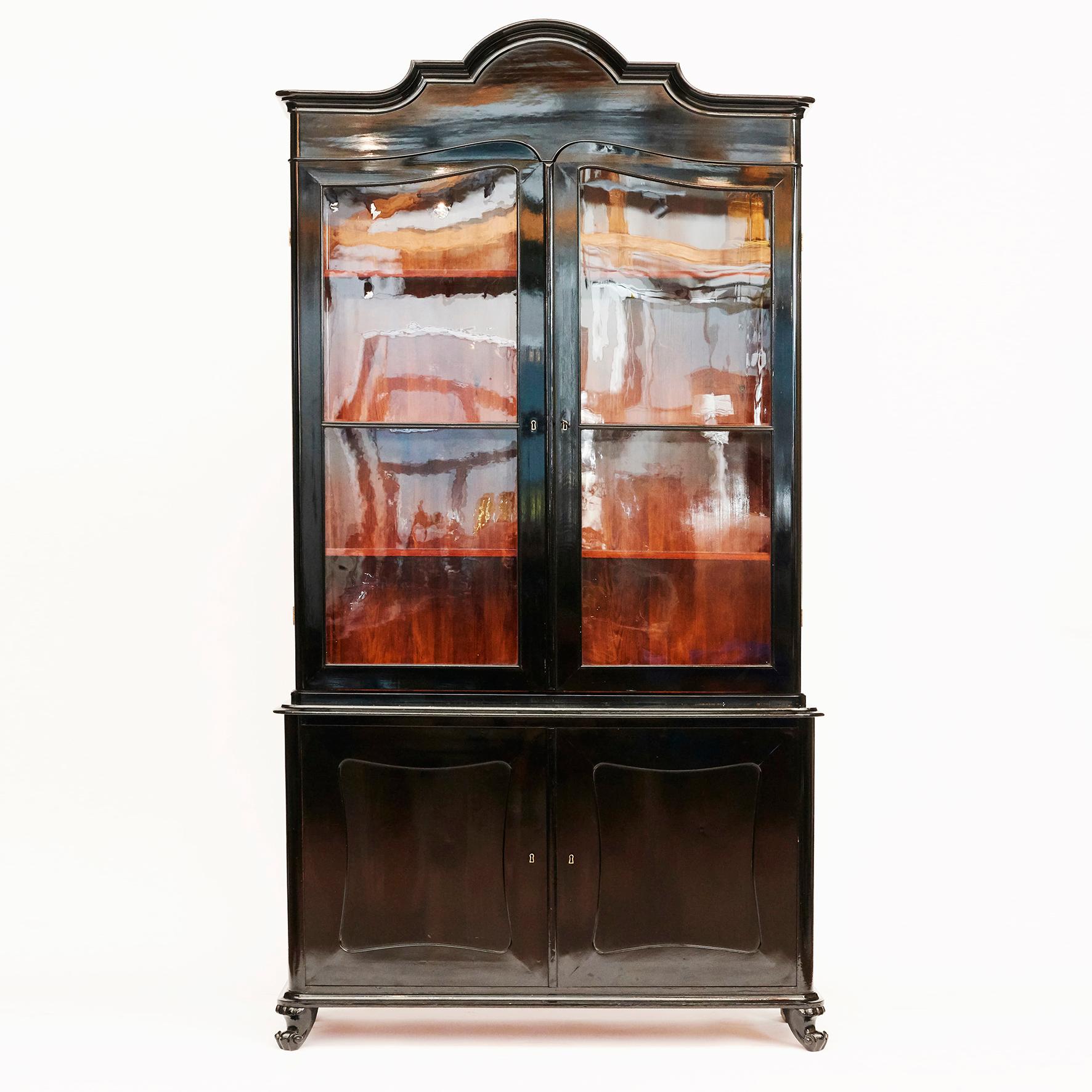 A beautiful late Empire 4-doors glass and wood cabinet / / bookcase in black polished mahogany.
Pair of locking paned glass doors sitting atop pair of locking wood doors with fillings. 

Late Empire / Chr. VIII, Denmark circa 1840-1860.

This
