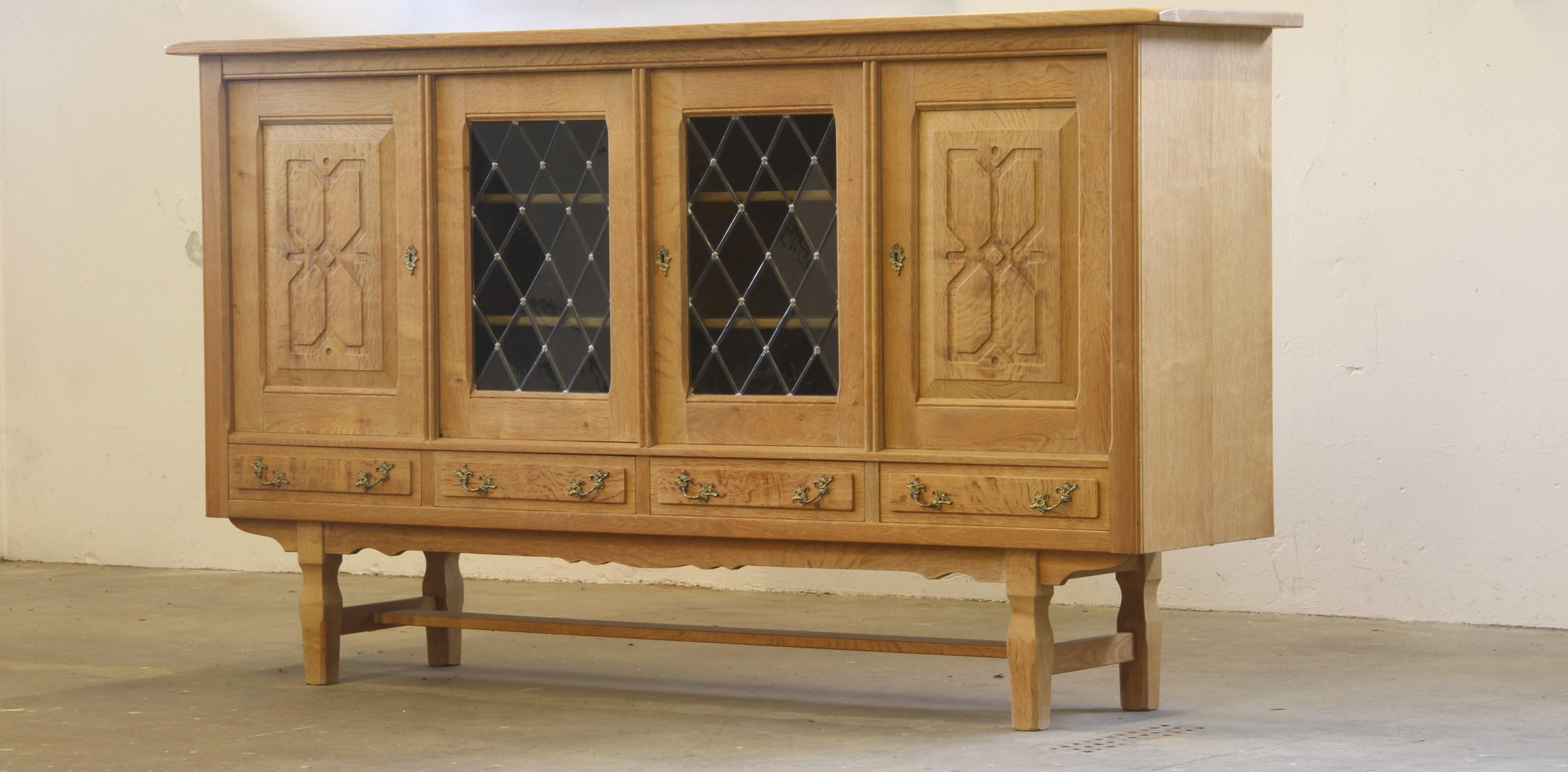 A striking cabinet made in Denmark during the 1960s or 70s, crafted from Nordic oak in the style of renowned Danish designer Henning Kjærnulf. Known for blending Scandinavian Modernism with medieval, baroque, and even Viking influences, Kjærnulf’s