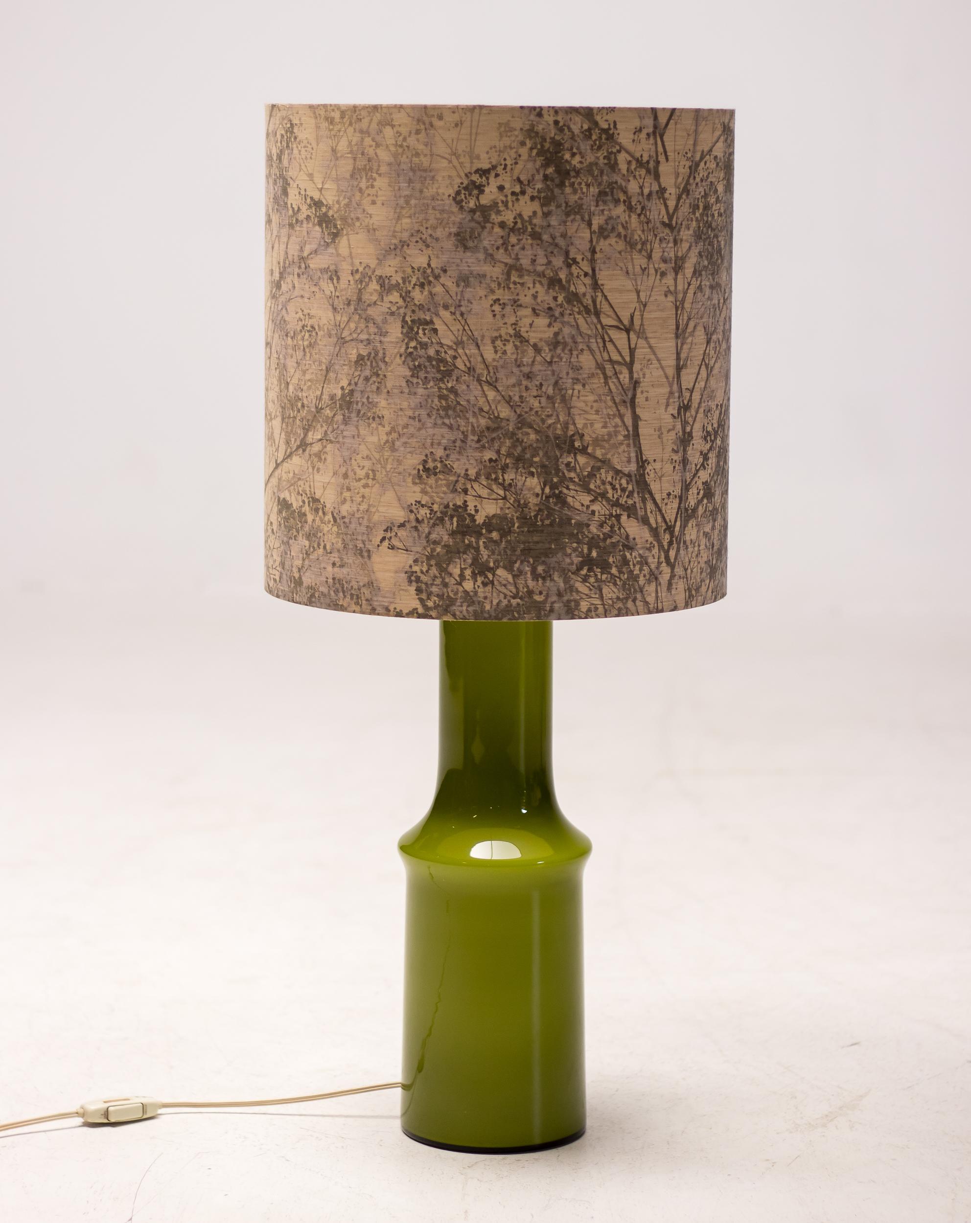 Beautiful large green glass table lamp by Holmegaard, Denmark.
The shade is easily replaceable, but it is in good condition and has a charming nature decoration.
The base is in excellent condition and it is wired for use in the USA.