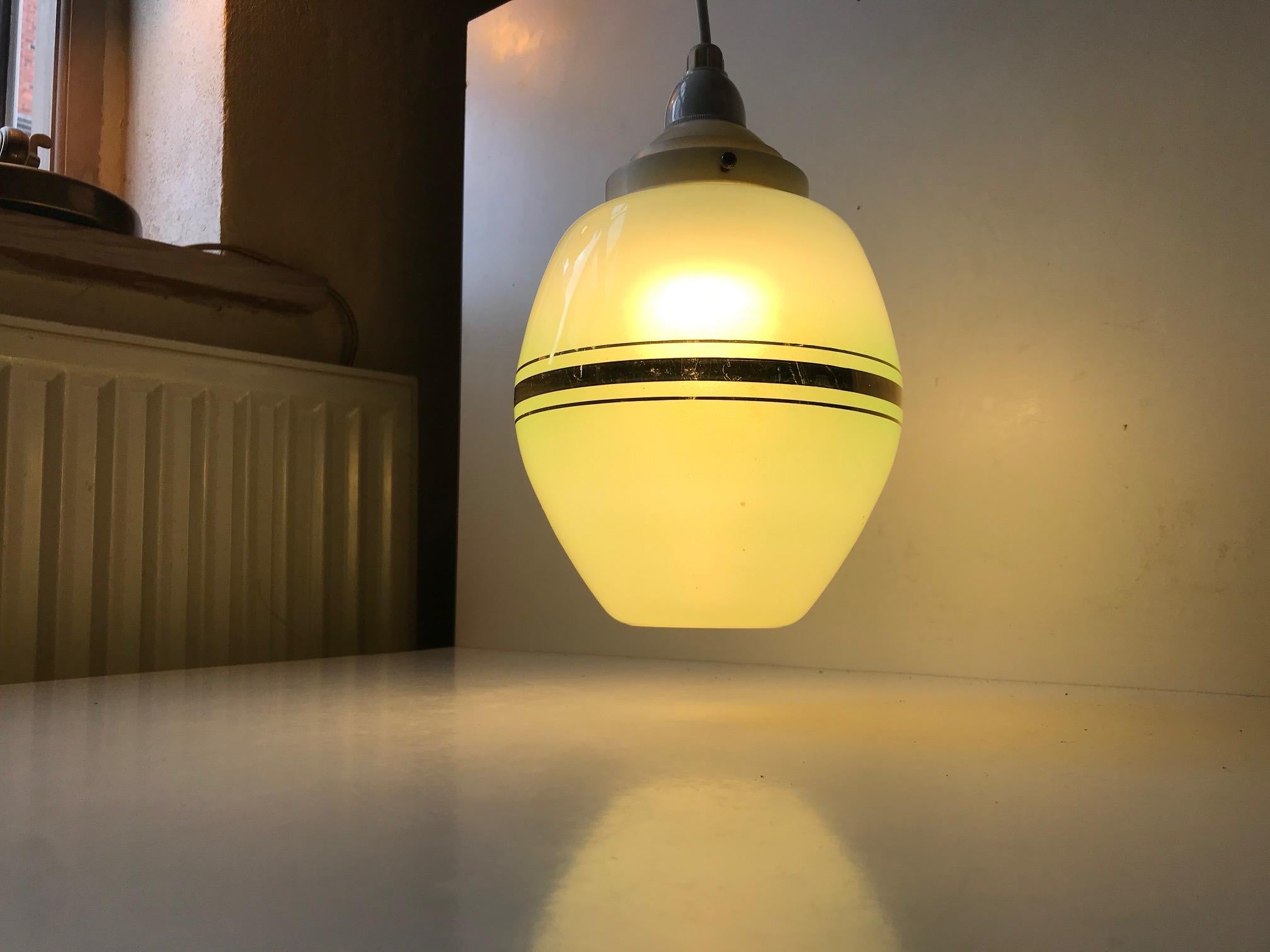 Small organically shaped hanging lamp composed of white and green opaline glass with gold foliage stripes and original Bakelite top and socket. It was manufactured by Lyfa in Denmark during the 1930s or 1940s. Imprint from Lyfa to the socket.