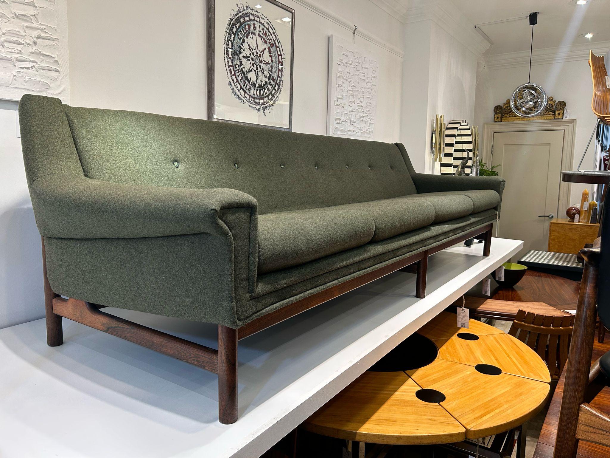 Ce canapé en laine vintage saisissant capture l'essence du design du milieu du siècle. Récemment revêtu d'une riche laine de couleur vert mousse, avec de subtils boutons en tissu écossais, ce canapé offre un aspect chaleureux, à la fois accueillant