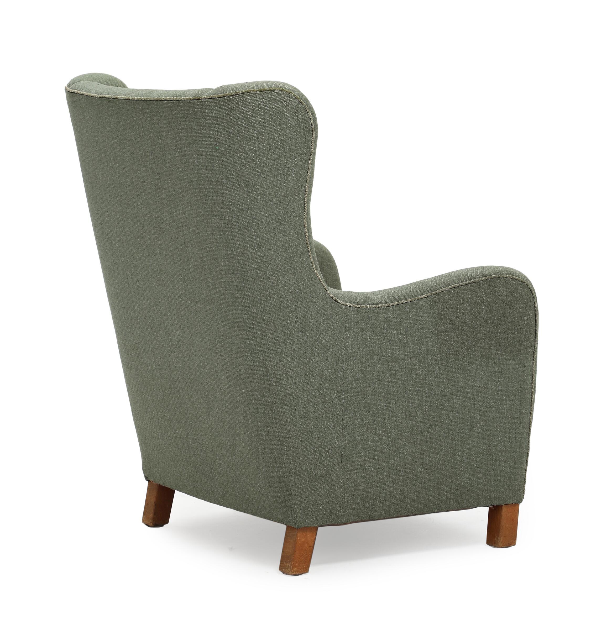 Danish green wool easy chair with beech wood legs. 1930–40s.

Wear due to age and use. Marks and scratches. Upholstery with stains and dirt.