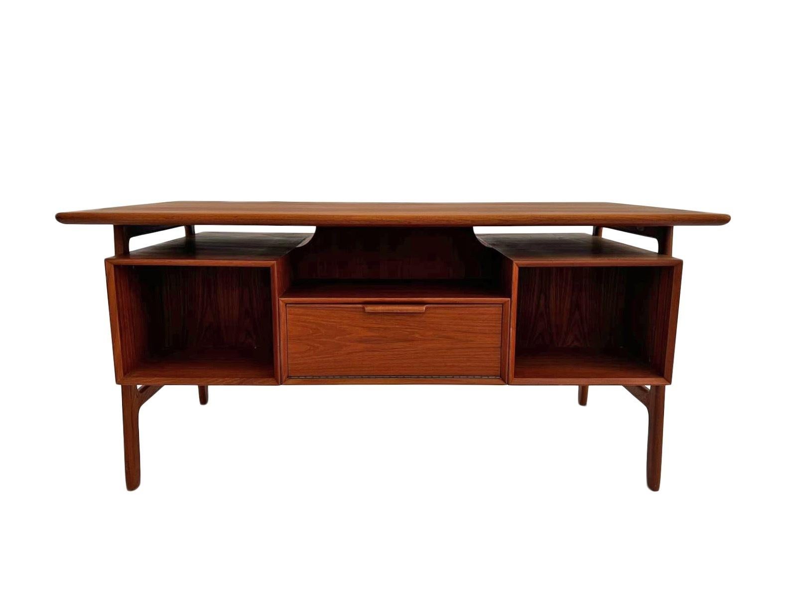 A beautiful Danish Model 75 teak writing desk designed by Gunni Omann for Omann Jun Møblefabrik, this would make a stylish addition to any work area. A striking piece of classically designed Scandinavian furniture.

The desk has two banks of three