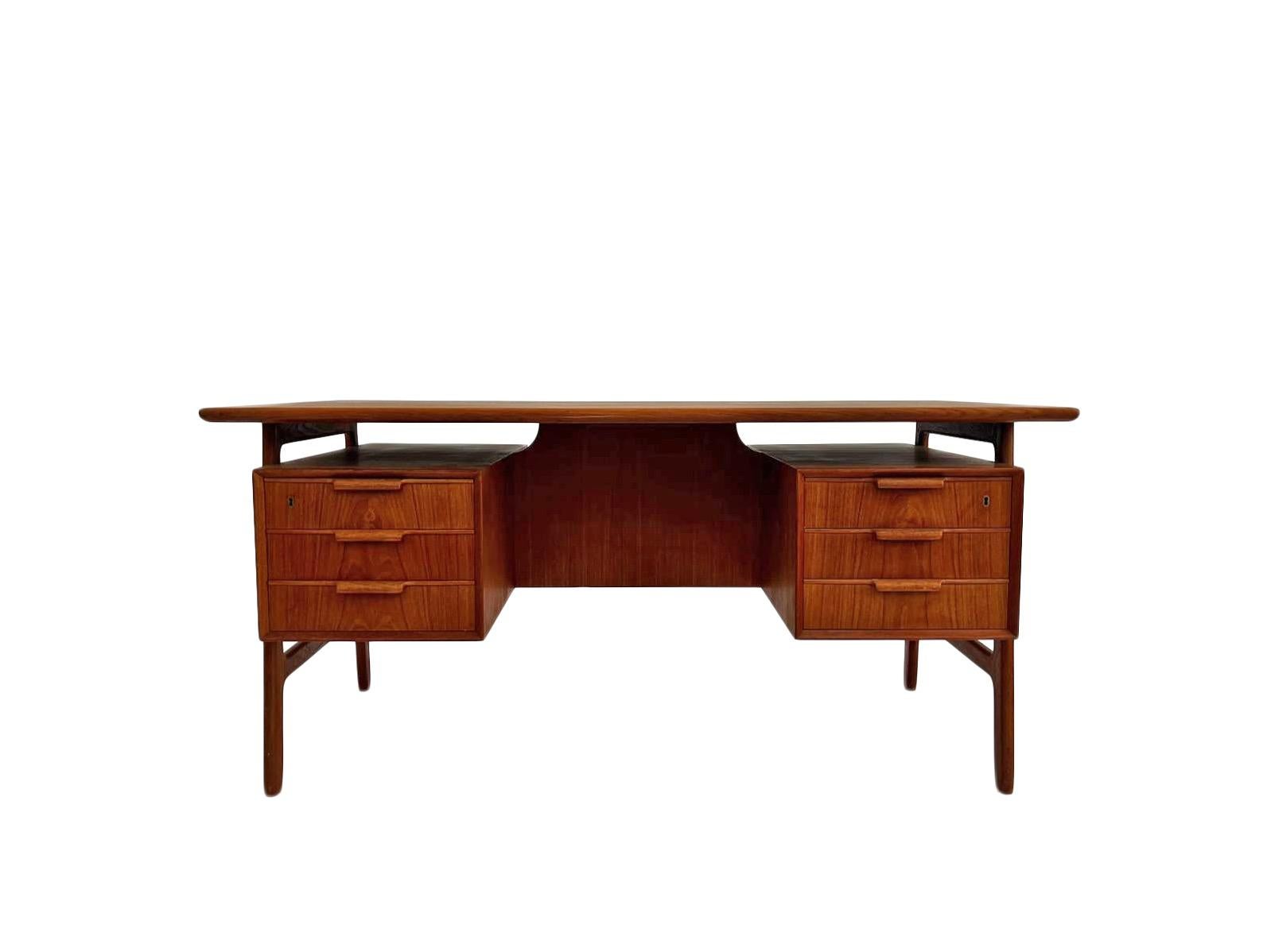 A beautiful Danish Model 75 teak writing desk designed by Gunni Omann for Omann Jun Møblefabrik, this would make a stylish addition to any work area. A striking piece of classically designed Scandinavian furniture.

The desk has two banks of three