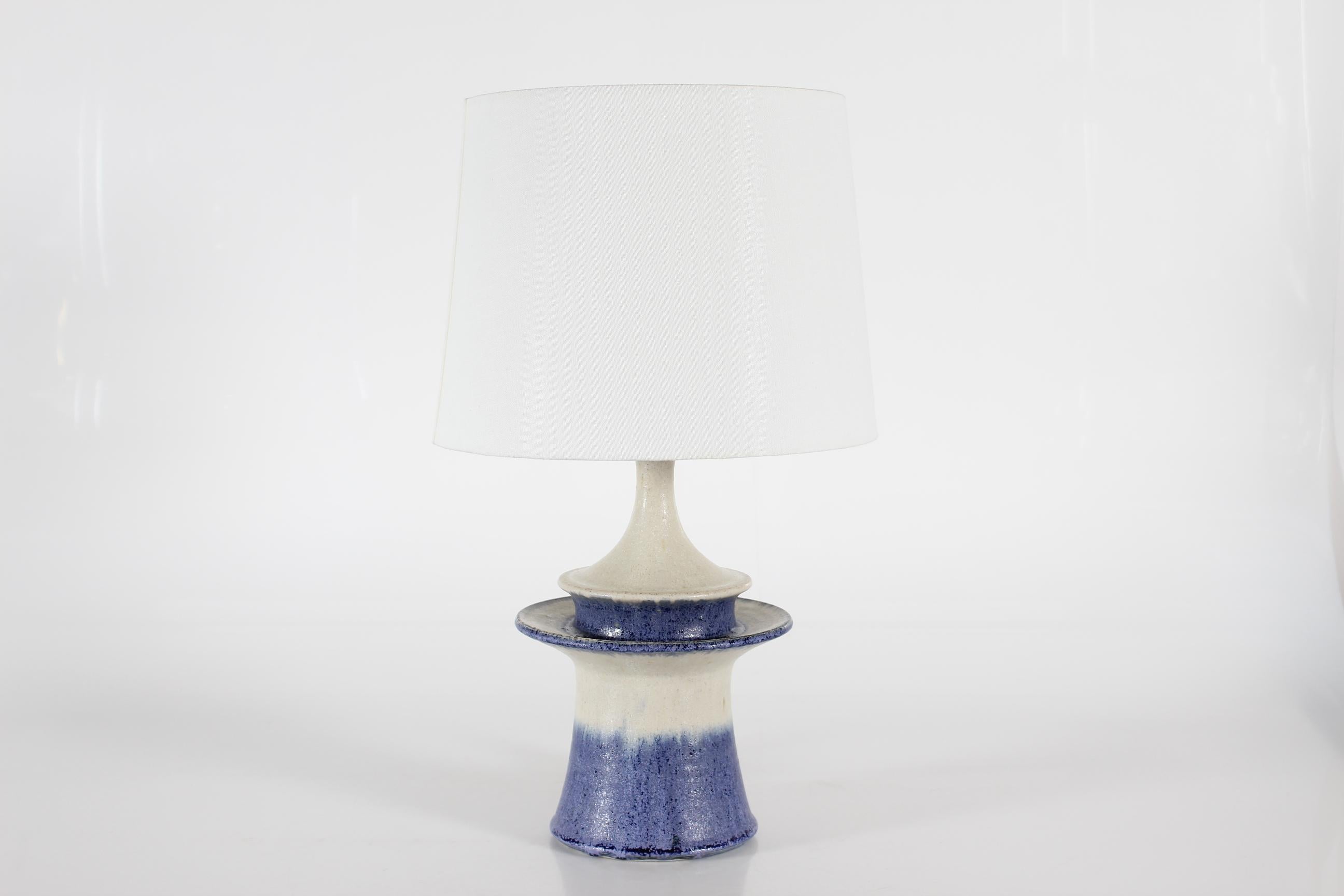 Lampe de table danoise sculpturale du milieu du siècle réalisée au studio de céramique Kähler (HAK).  par le céramiste britannique Carl Cunningham-Cole (1942-2015).

La base de la lampe est en grès docorée d'une glaçure rustique blanc cassé et bleu