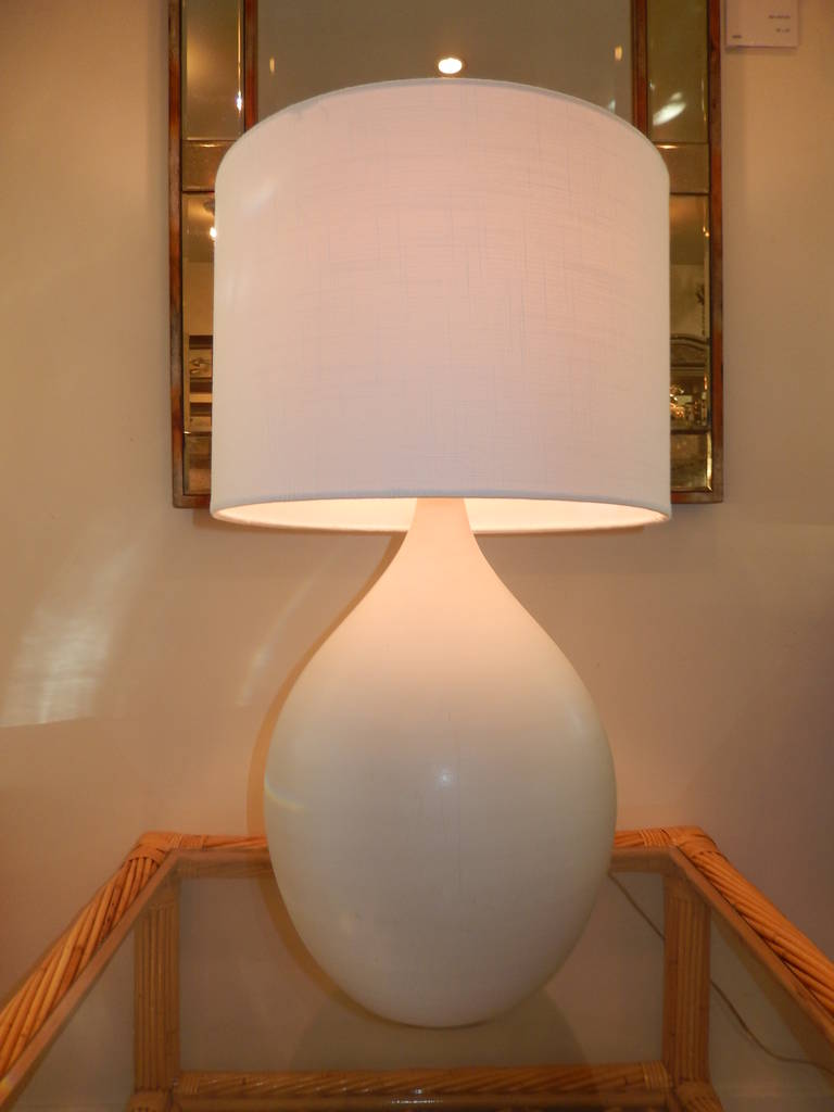 A bulbous form hand-thrown and hand studio crafted white bisque pottery table lamp. Three way switch, clear cord, new linen shade. Measures 20 inches to the socket and 27 inches to the top of the shade.