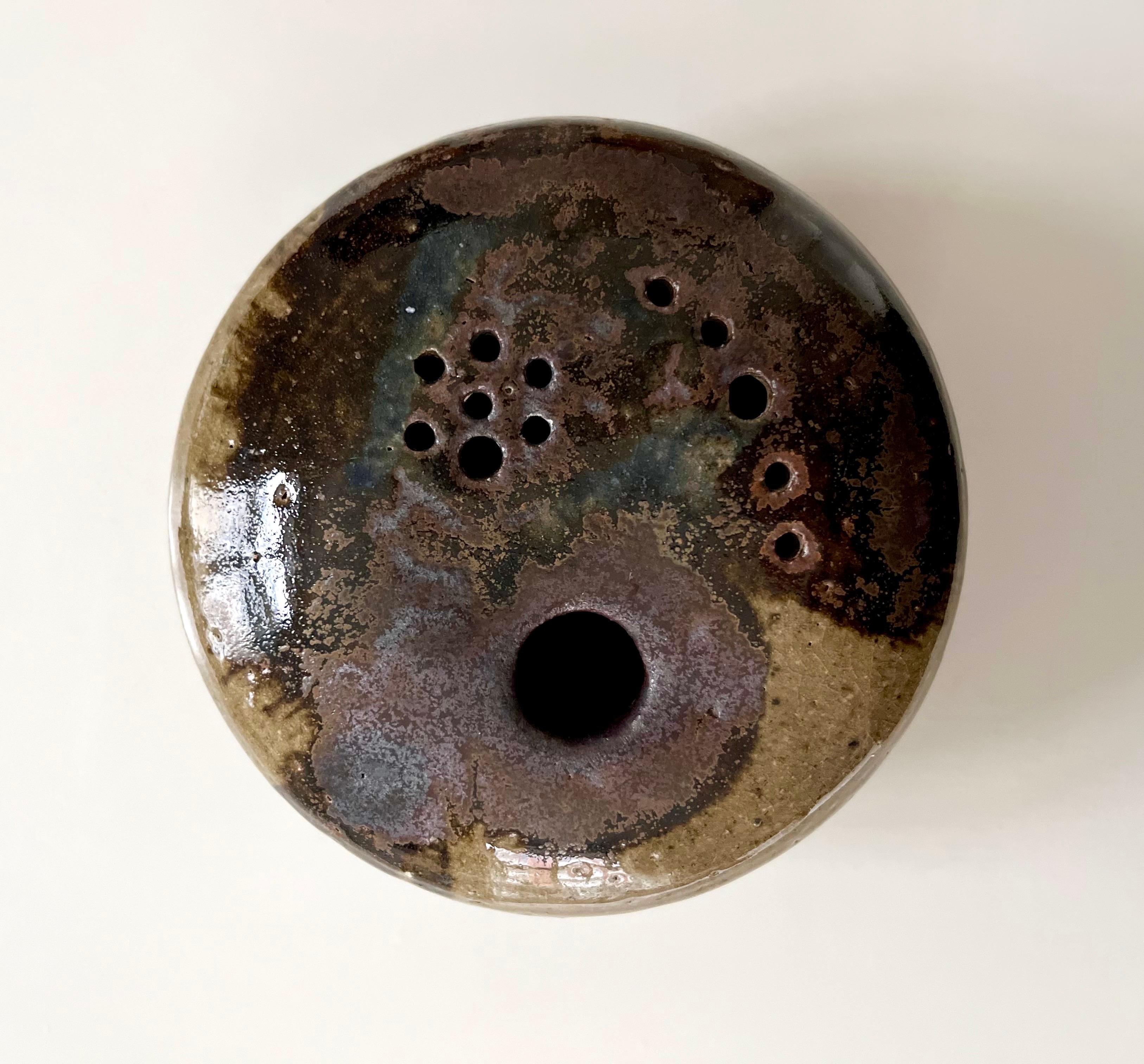 Jarrón redondo de cerámica danesa hecha a mano, forma orgánica, esmalte de lava, años 60

Singular jarrón de cerámica artesanal danesa con forma escultórica orgánica, que también funciona como recipiente hueco decorativo. 
El esmalte presenta un