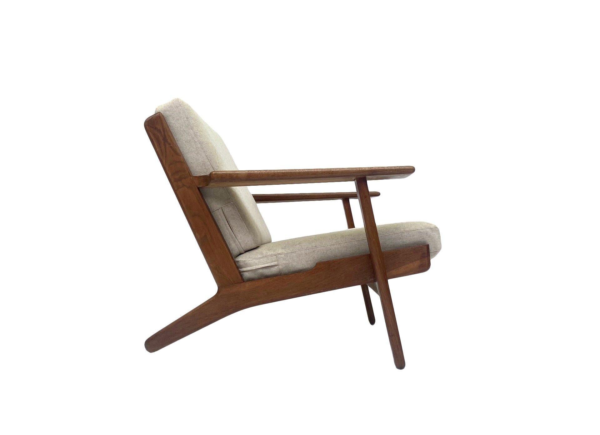 A beautiful Danish iconic Model GE-290 solid oak and cream wool lounge armchair designed by Hans J. Wegner for Getama in the 1950s, this would make a stylish addition to any living or work area. A striking piece of classic Scandinavian