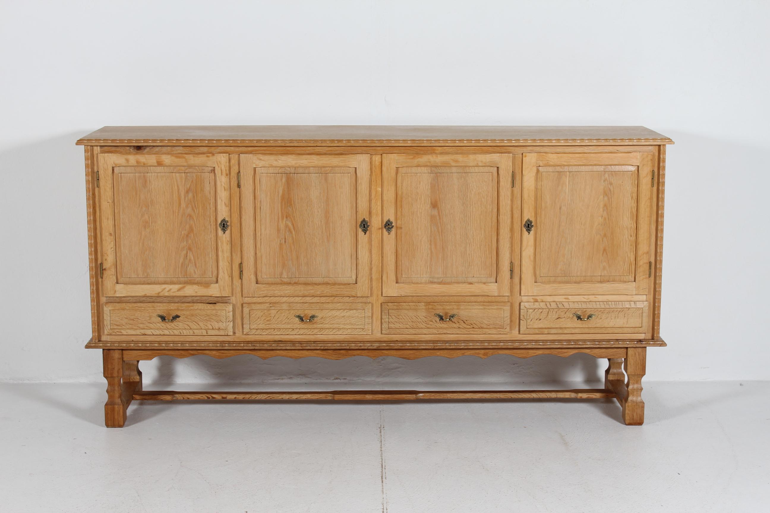 Hohe und lange Anrichte im Stil des Designers Henning Kjærnulf, die wahrscheinlich von der dänischen Firma Nyrup Møbelfabrik/ EG Furniture in Dänemark in den 1970er Jahren hergestellt wurde.

Das Sideboard im Landhausstil ist aus massiver Eiche