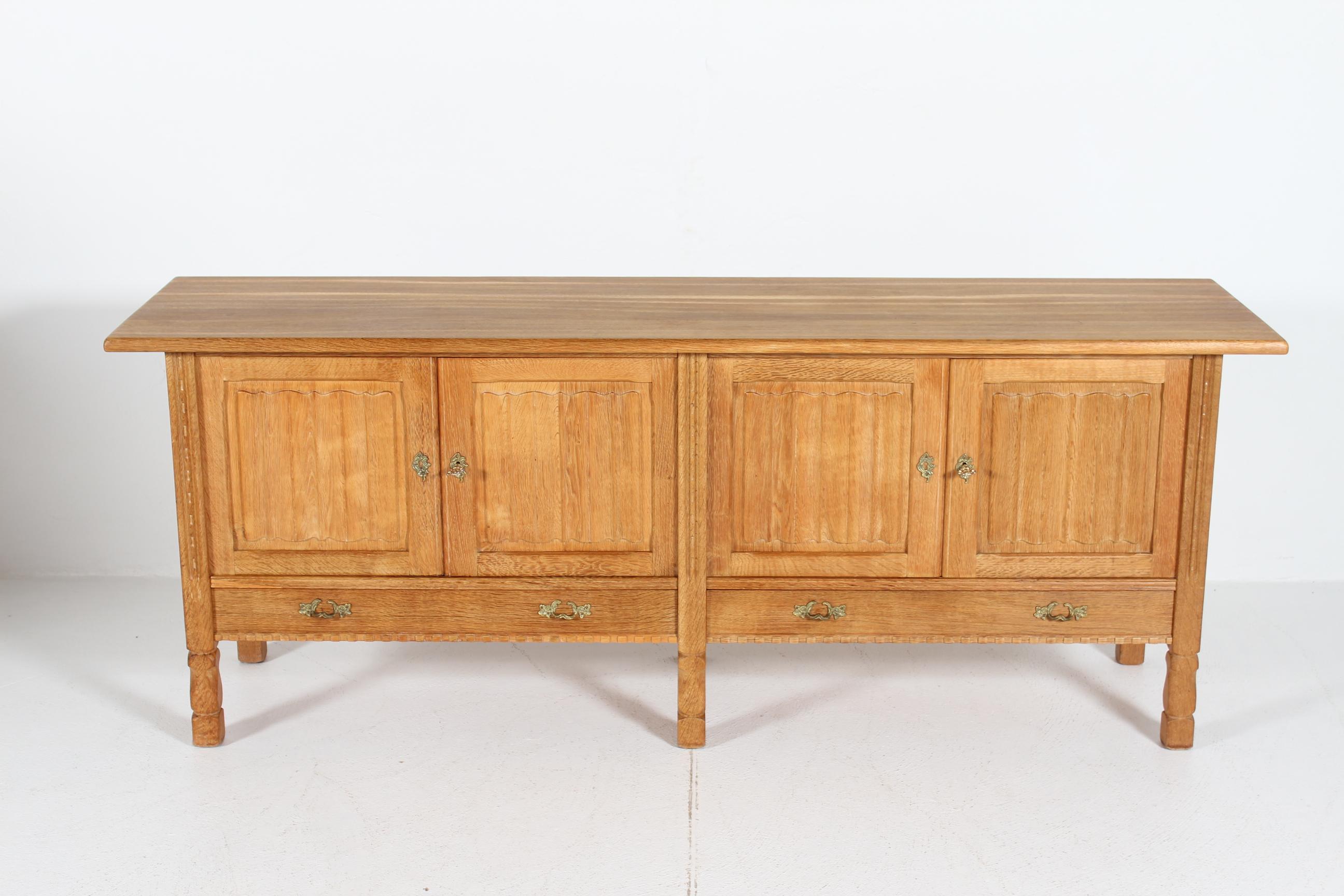 Long low sideboard attr. to designer Henning Kjærnulf.
Most likely manufactured by the Danish company Nyrup Møbelfabrik/ EG Furniture, Denmark in the 1970s.

The country and brutalist style sideboard is made of solid and veneered oak with four