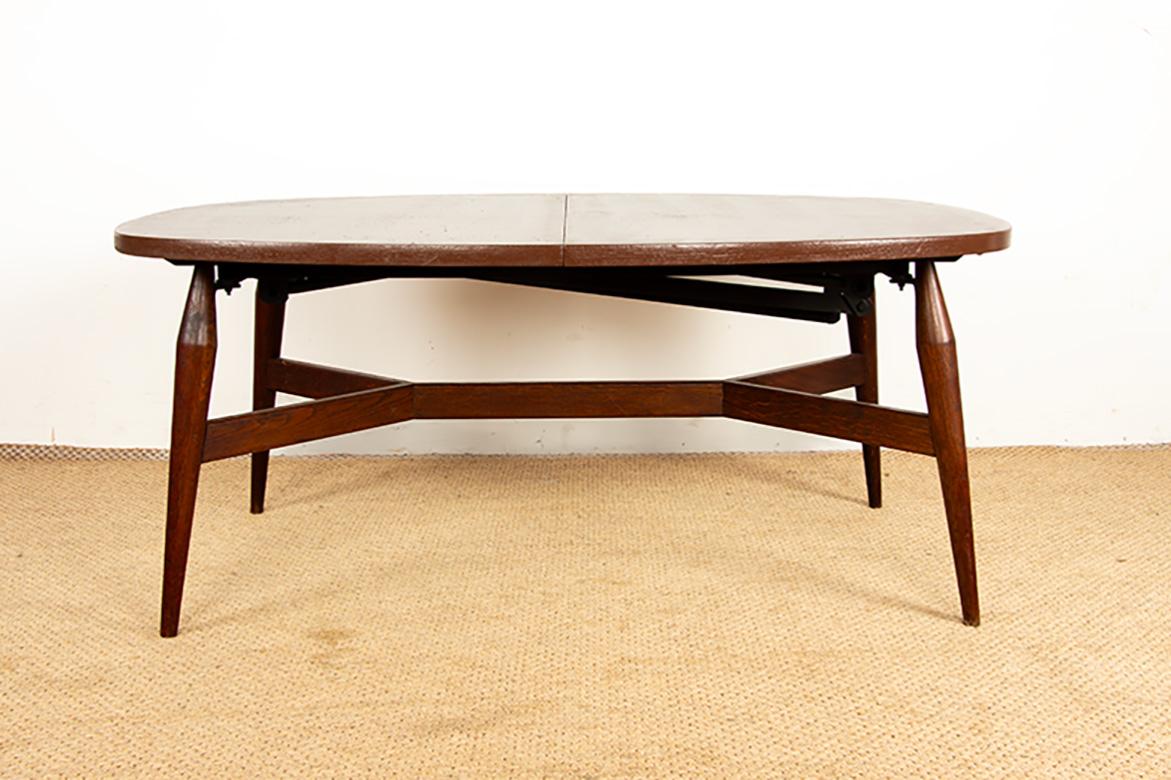 Scandinavian table that combines both a coffee table and a dining table thanks to a clever metal mechanism that allows the table to be raised in one movement. Superb, airy teak base, relacquered brown top. Separate extension for the high dining