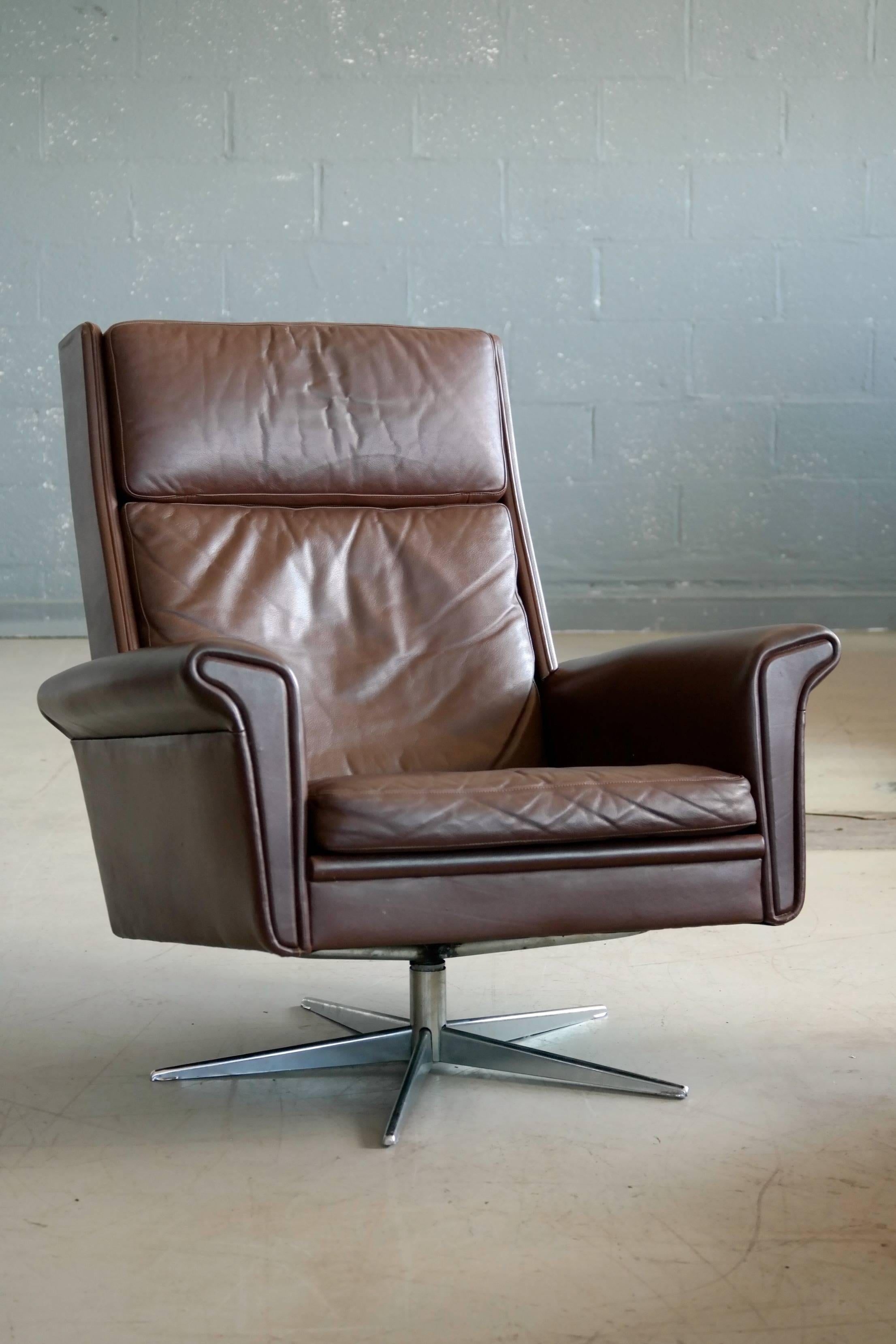 Modern and luxurious swivel chair in supple brown chocolate colored leather on a chrome-plated aluminum swivel base. Beautiful example of Danish Modern at its best designed by Georg Thams, circa 1969 and produced sometimes in the early 1970s. The