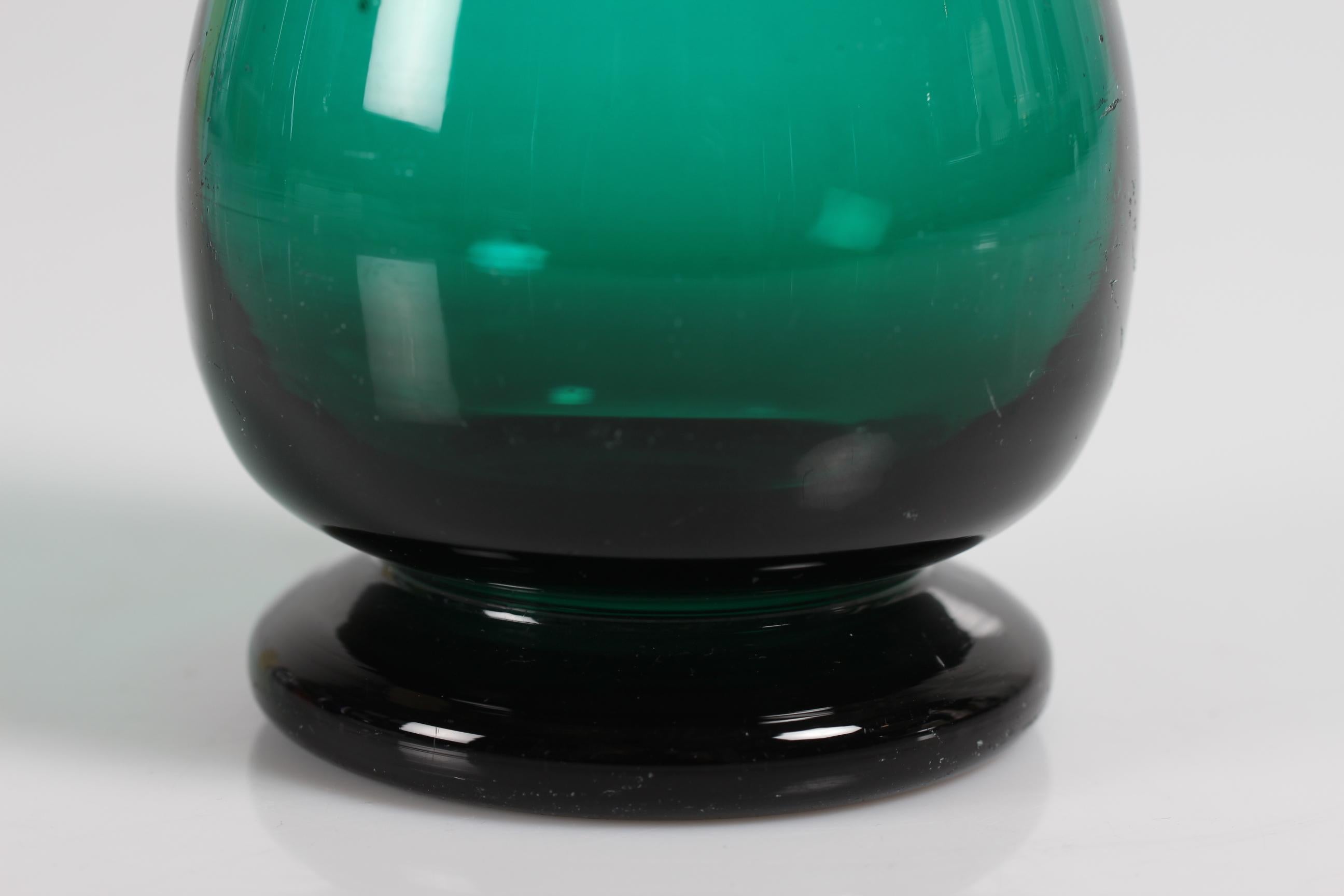 Old Danish hyacinth glass or vase from Holmegaard or Kastrup glassworks, circa 1850.
It is registered in the Holmegaard catalog in 1853

The smooth mouth blown green glass has a baluster form and a small foot

Measures: Height 21 cm
Diameter 8