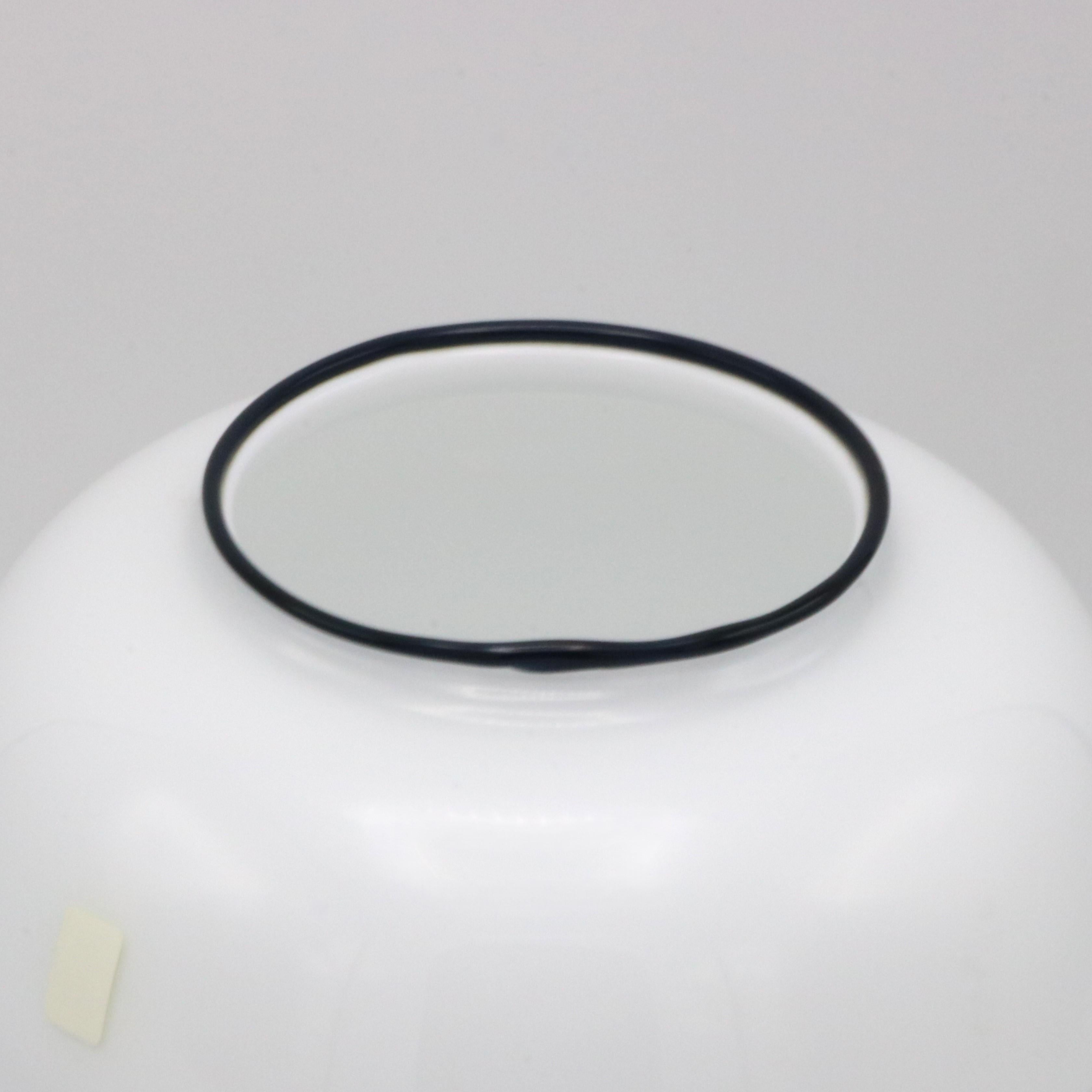 Vaso in vetro Holmegaard disegnato da Michael Bang, Danimarca, circa 1970. Il vetro bianco opaco con bordo blu e motivi a volute presenta un disegno continuo lungo tutto il perimetro.