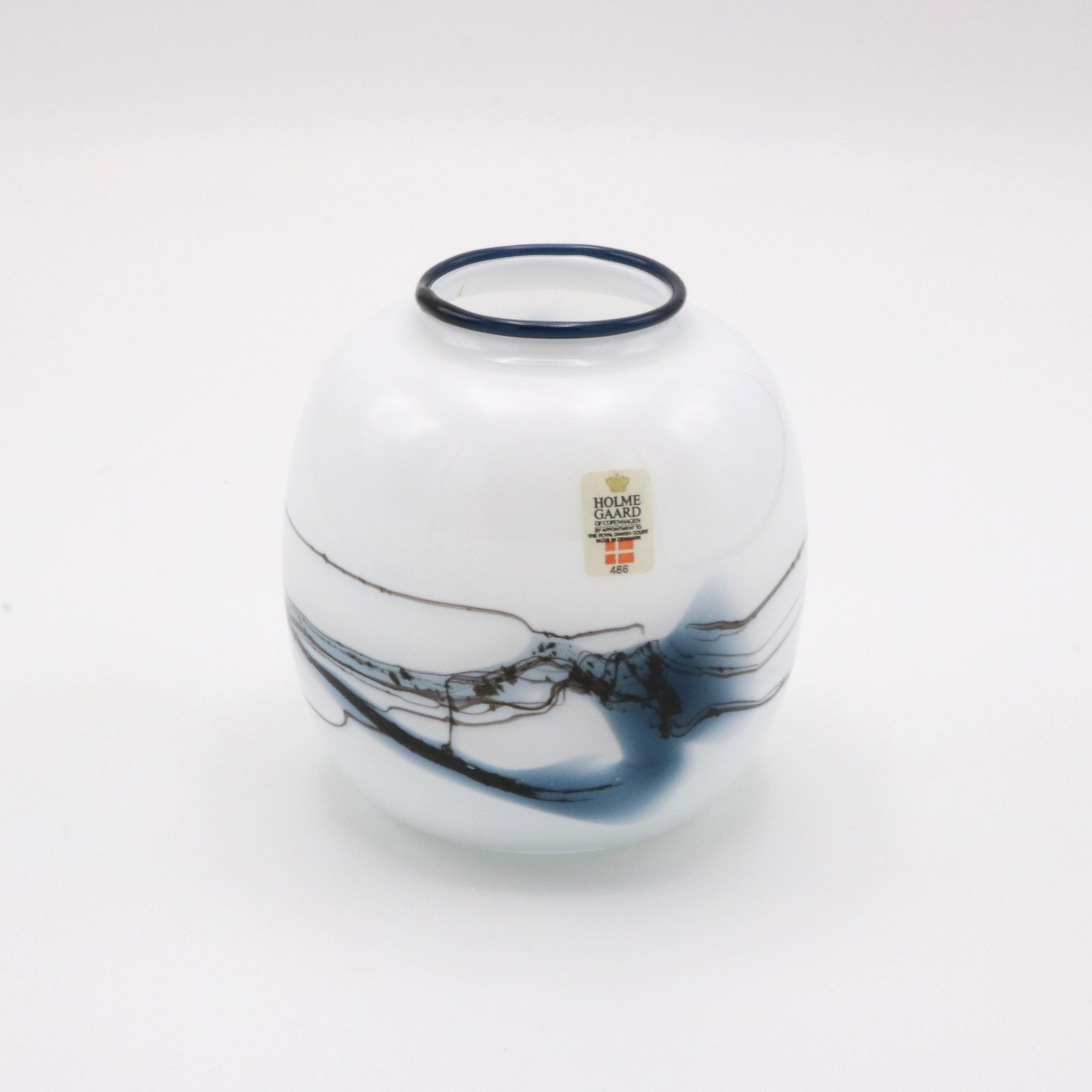 Vaso in vetro danese Holmegaard disegnato da Michael Bang, Danimarca, 1970 circa. Il vetro bianco opaco presenta motivi asimmetrici di volute blu.