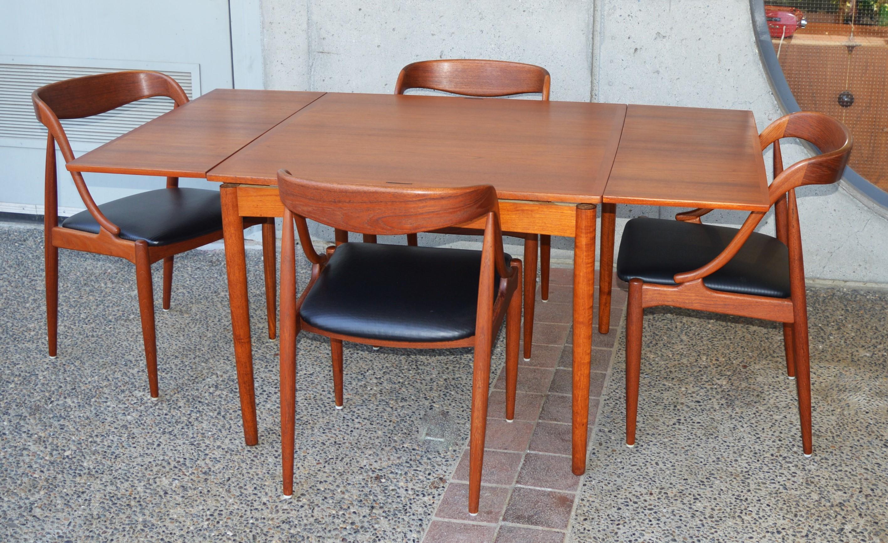 This rare Danish modern teak draw leaf dining table has two extension leaves that live under the tabletop and are drawn from the ends of the table when needed. An early design by Hundevad & Co. (note their early logo branded underneath as well as
