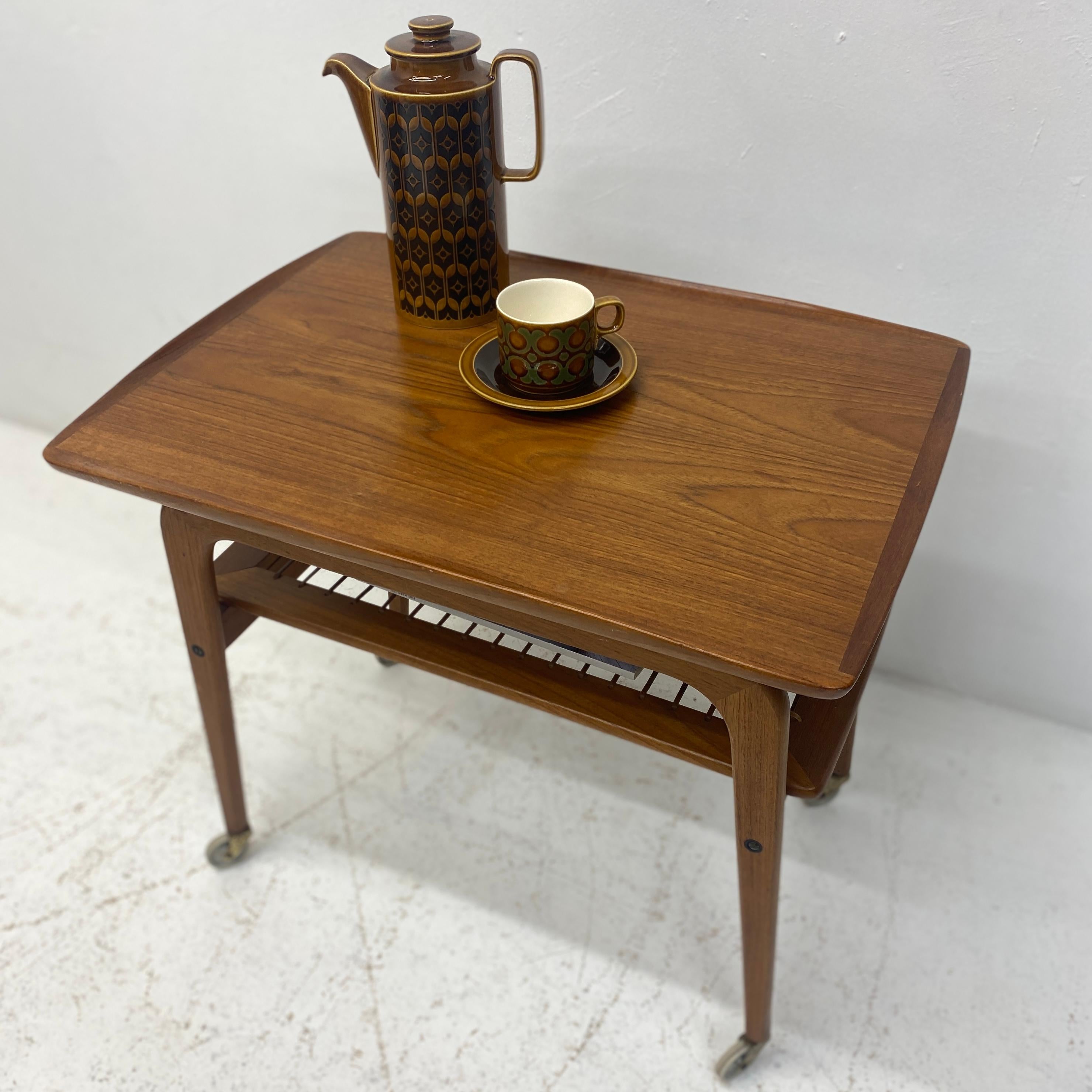 A superb Danish Johannes Anderson midcentury trolley or side table. The trolley is a stunning design with great curves & a beautiful shape. It is constructed from teak & rattan & is therefore very tactile. It sits on its original castors so can