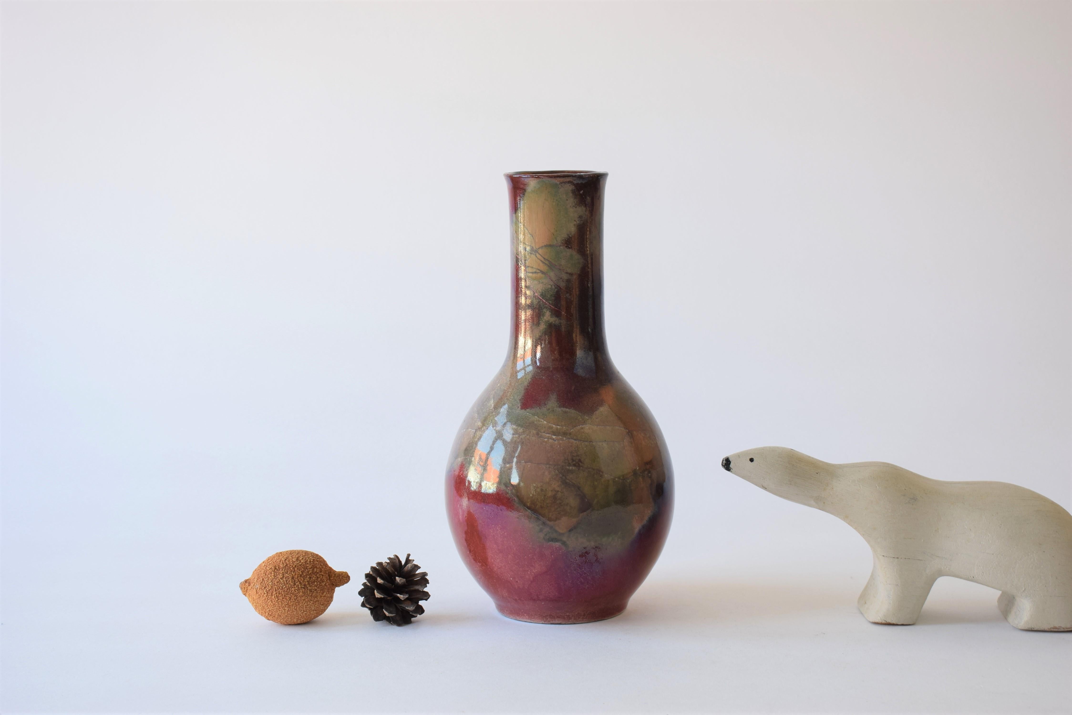 Tall vase from the Danish ceramic workshop Herman August Kähler (HAK). It has a stunning glaze with lots of red lustre and greyish elements. It looks very different from the different angles. It's made from earthenware and was manufactured in the