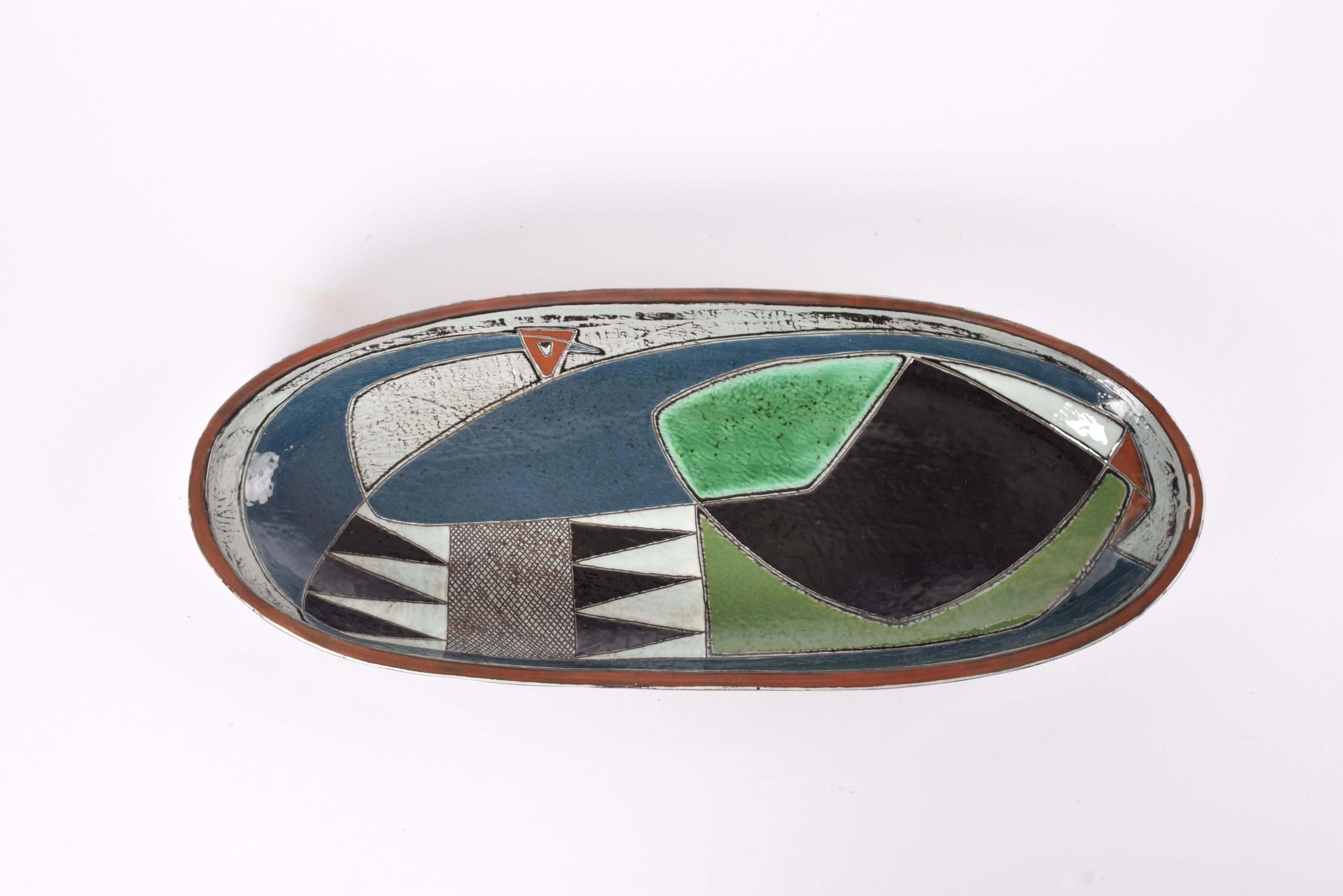 Huge oblong low bowl from Kähler´s ceramic workshop in Denmark. Made ca 1950s.

The shape of the bowl was designed and made by Nils Kähler and the hanpainted decoration is by artist Gete Petersen.

The decor shows a large stylised bird and it's