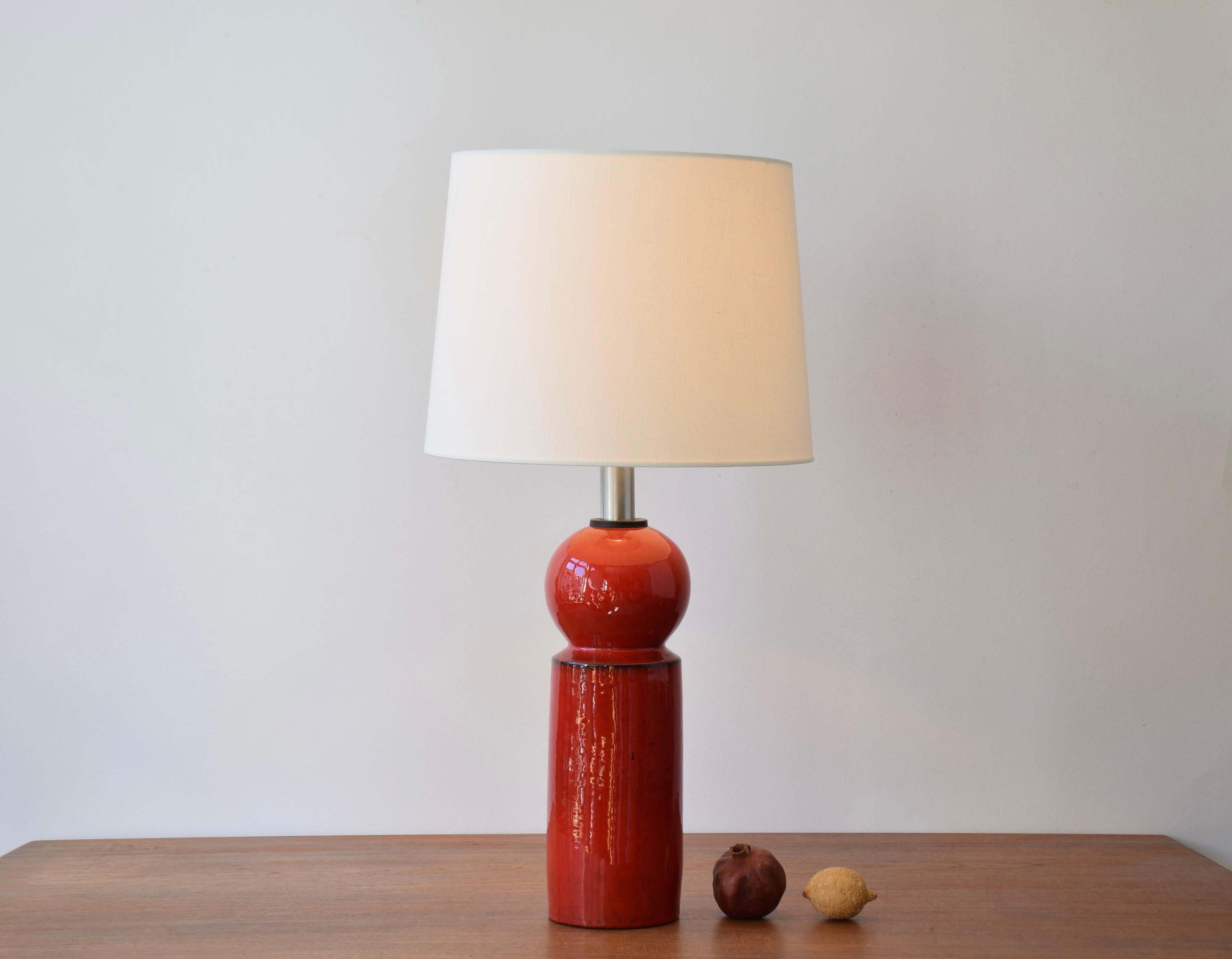 Tall sculptural ceramic table lamp designed by Danish ceramist Allan Schmidt. It's manufactured by Herman A. Kähler´s ceramic workshop in cooperation with Danish lamp manufacturer LYFA ca 1960s. 

It is decorated with a shiny red glaze with darker