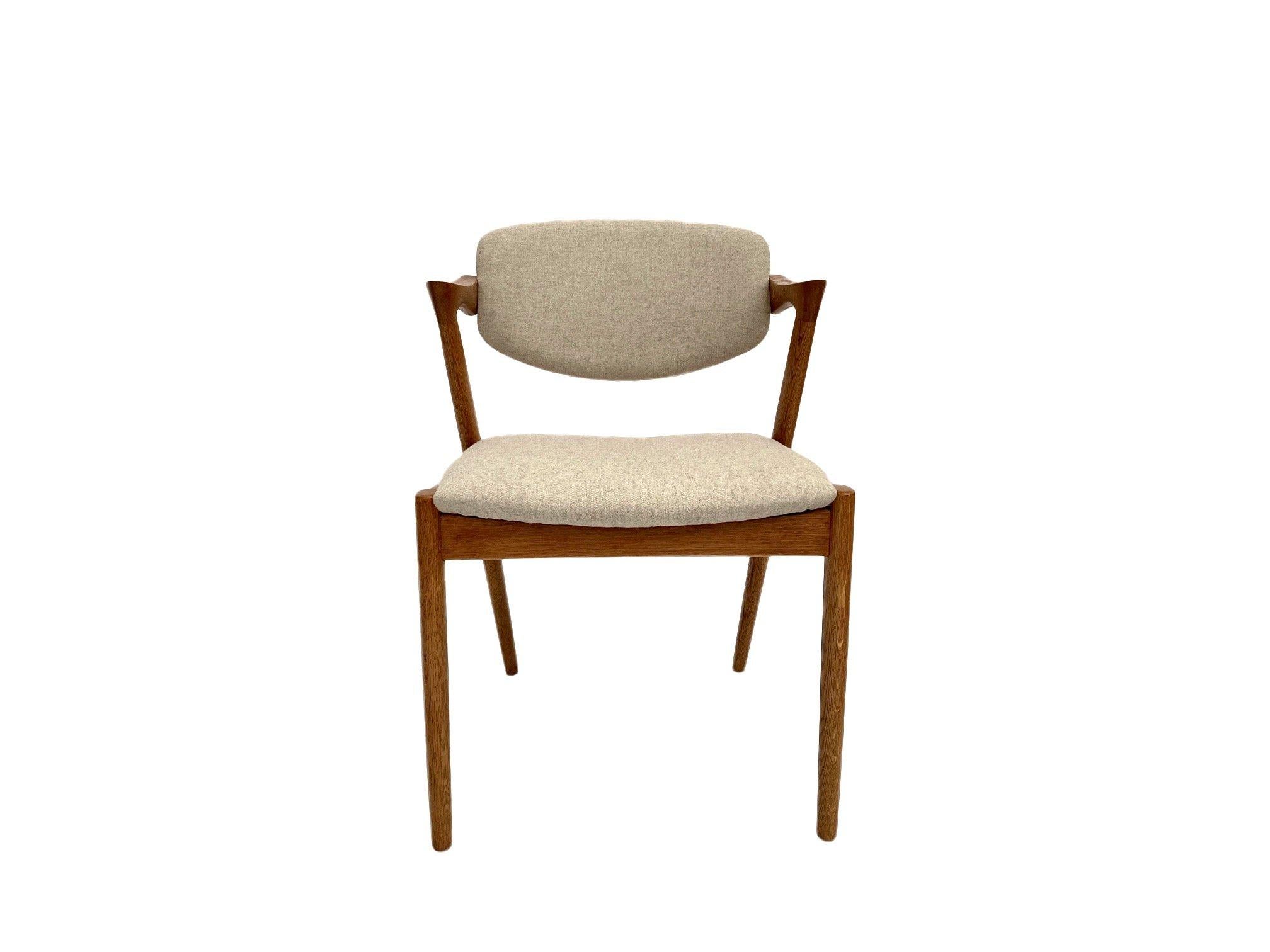 A beautiful set of 4 iconic Model 42 oak and cream wool dining chair designed by Kai Kristiansen for Shous Møbelfabrik, these would make a stylish addition to any dining area.

The chairs have wide seat pads and a tilting sculptured backrests for
