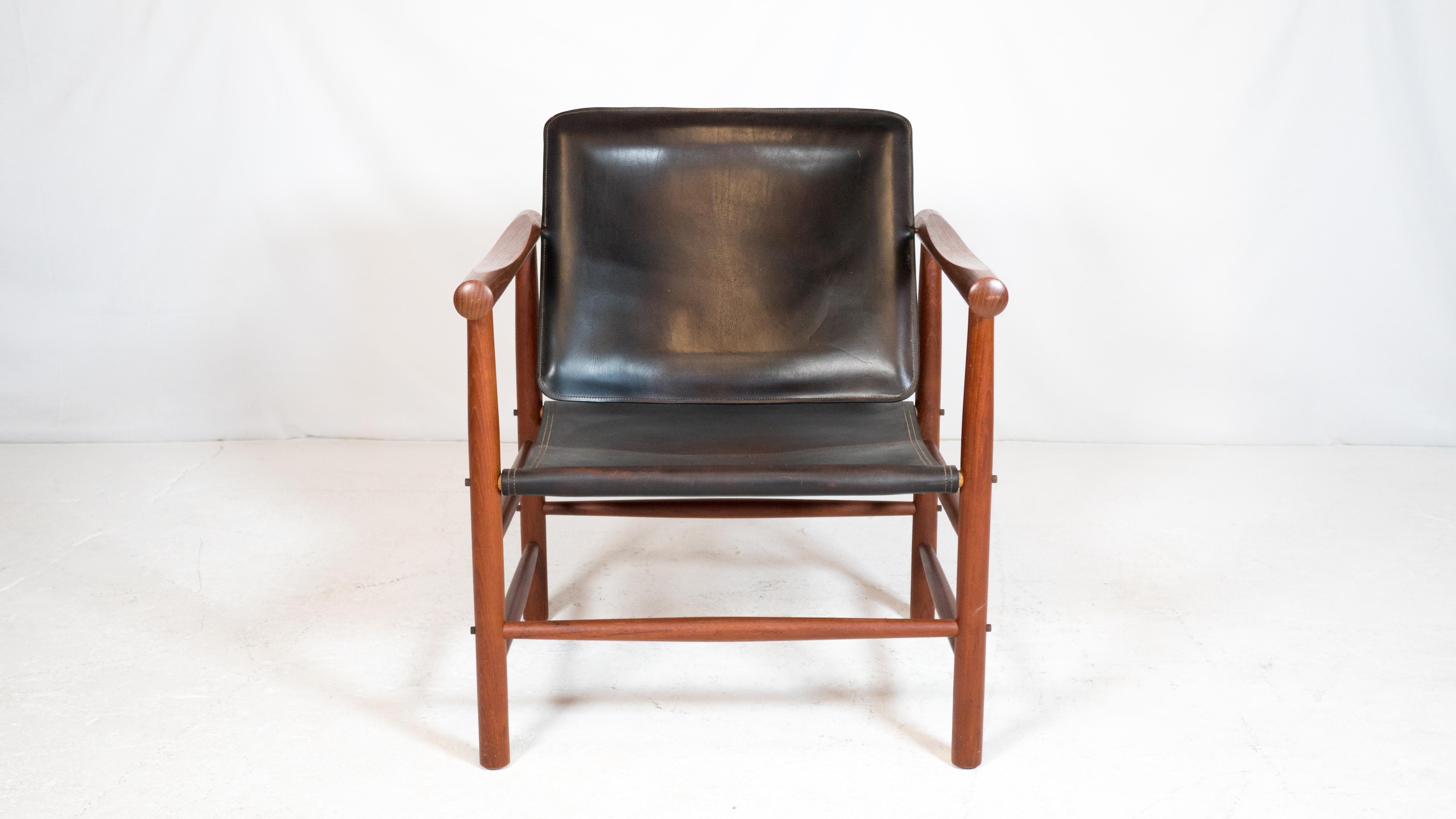 'Model 506' chair designed by Kai Lyngfeldt Larsen for Søborg Møbler, circa 1960s. Original black saddle leather with light patina showing the natural brown undertone of the leather. Solid teak construction, exposed stitching details, brass hardware