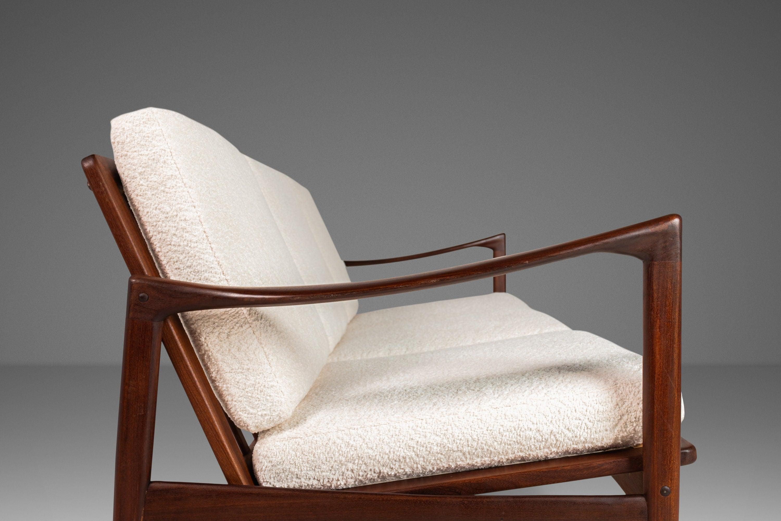 Dieses dreisitzige Kandidaten-Sofa wurde von Ib Kofod-Larsen entworfen und 1962 in Schweden von Olof Person hergestellt. Dieses ikonische Design aus massivem Teakholz zeichnet sich durch zylindrische, konisch zulaufende Beine mit langen, gebogenen