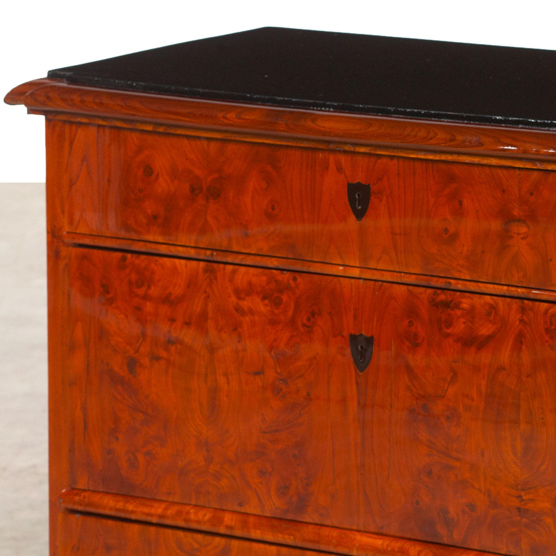 Danish Late Empire chest of drawers (also called Biedermeier), elmwood veneered with ebonized top, 1820-1830. The chest of drawers has a natural beautiful patina. The finish is French polish.