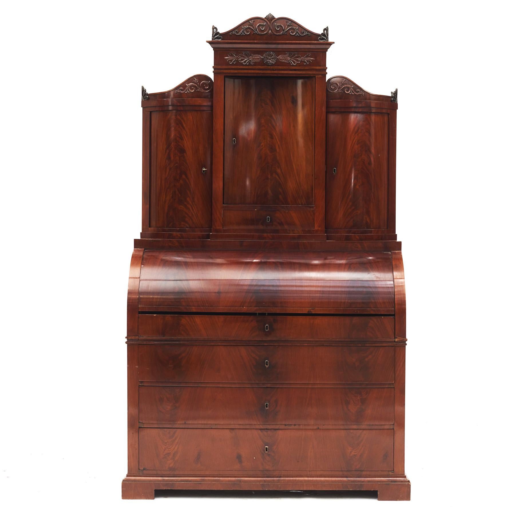 Late empire secretary bureau in mahogany veneered oak with beautiful grain.
In 2 parts.
Desk top offers three bowed doors. A concave door in the middle flanked by pair of convex doors.
Lower section with a slant front that opens to a fitted