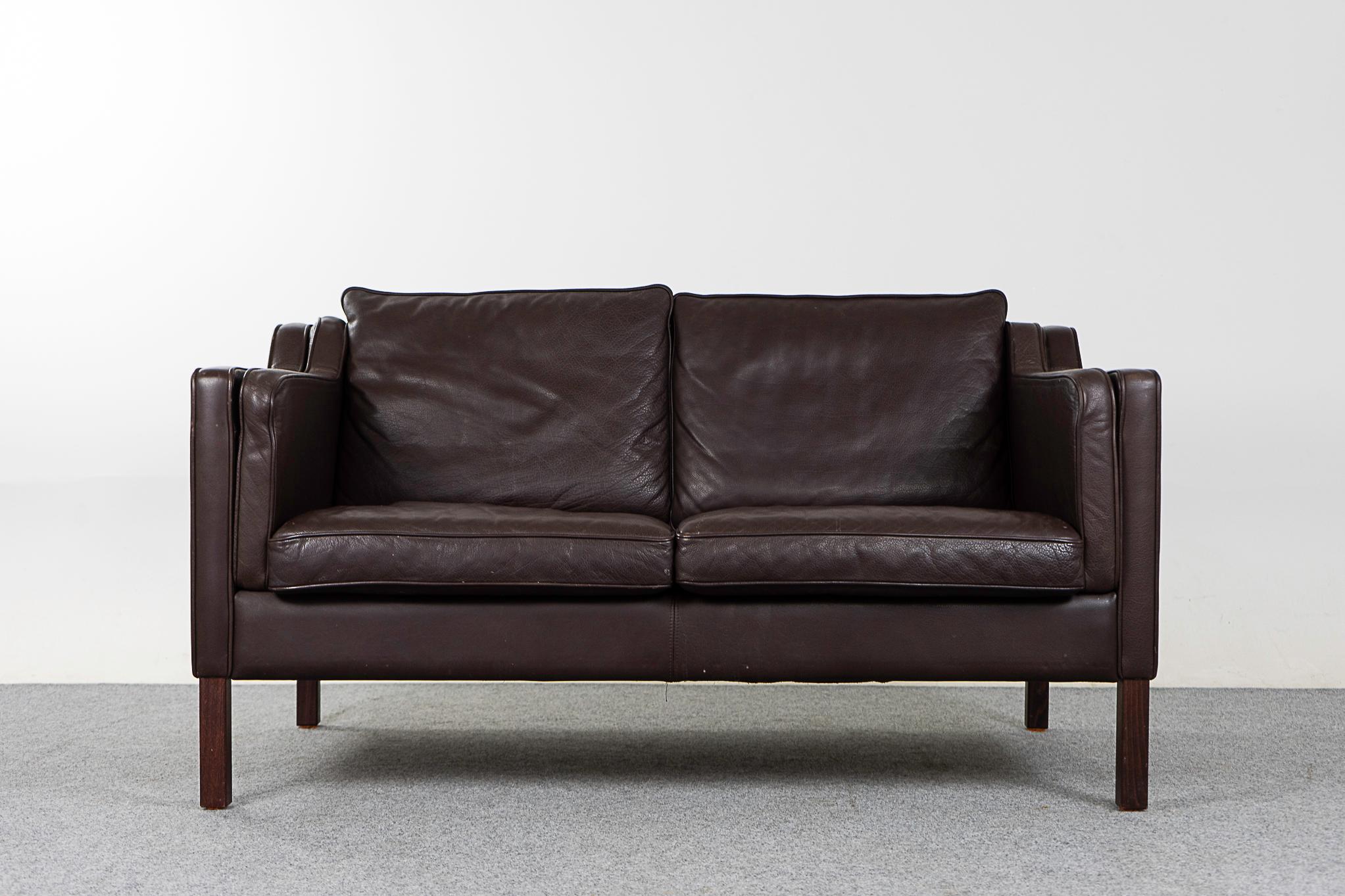 Leather mid-century loveseat by Stouby, circa 1960's. Original dark brown leather is soft and supple while also being durable to ensure years of use and enjoyment. Compact footprint make this the perfect seating solution for urban dwellers in cozy